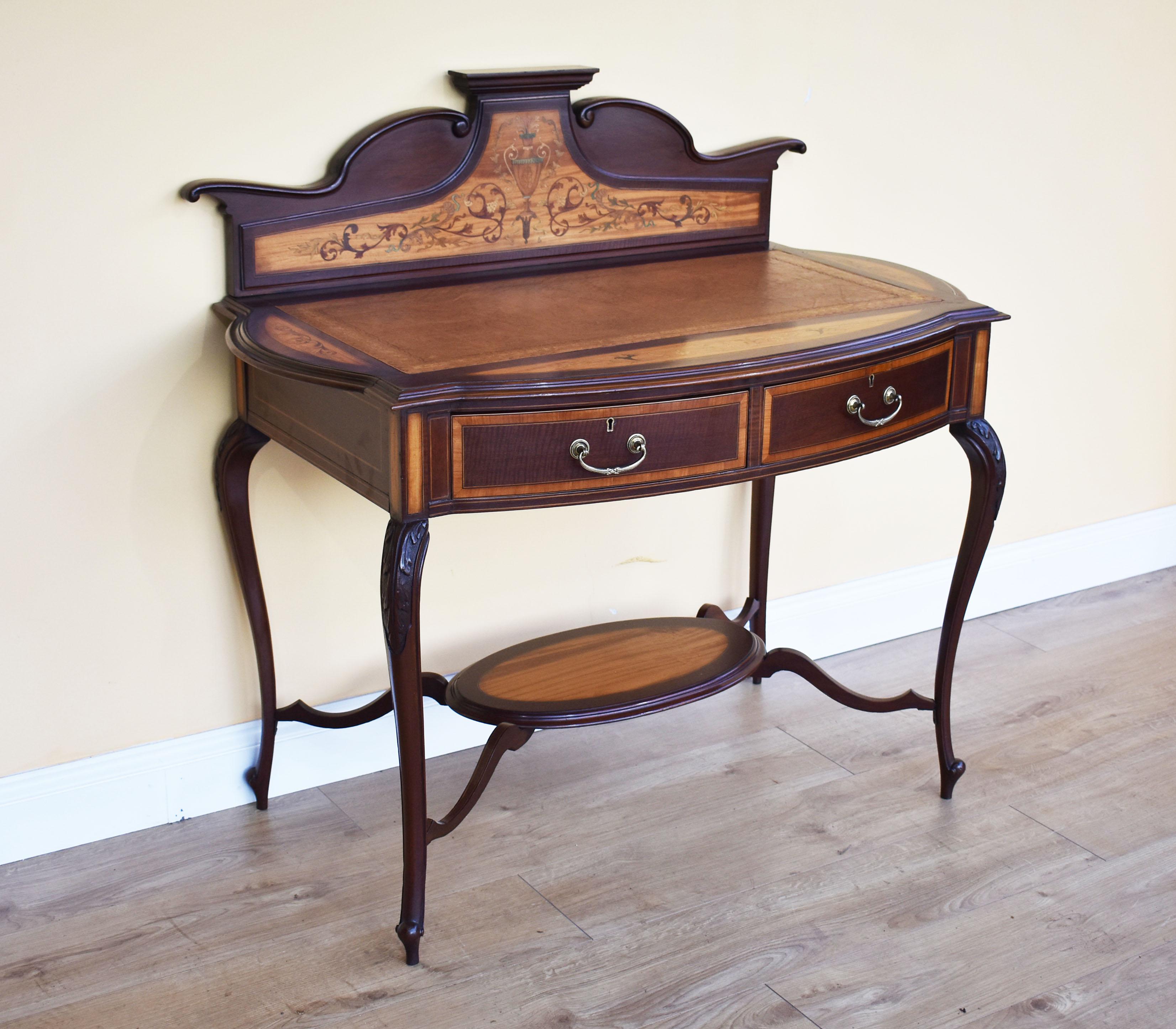 For sale is a fine quality 19th century mahogany and satinwood inlaid ladies writing table. The piece has a raised and shaped gallery to the back, with a satinwood panel profusely inlaid with various woods, over a tan leather insert with decorative