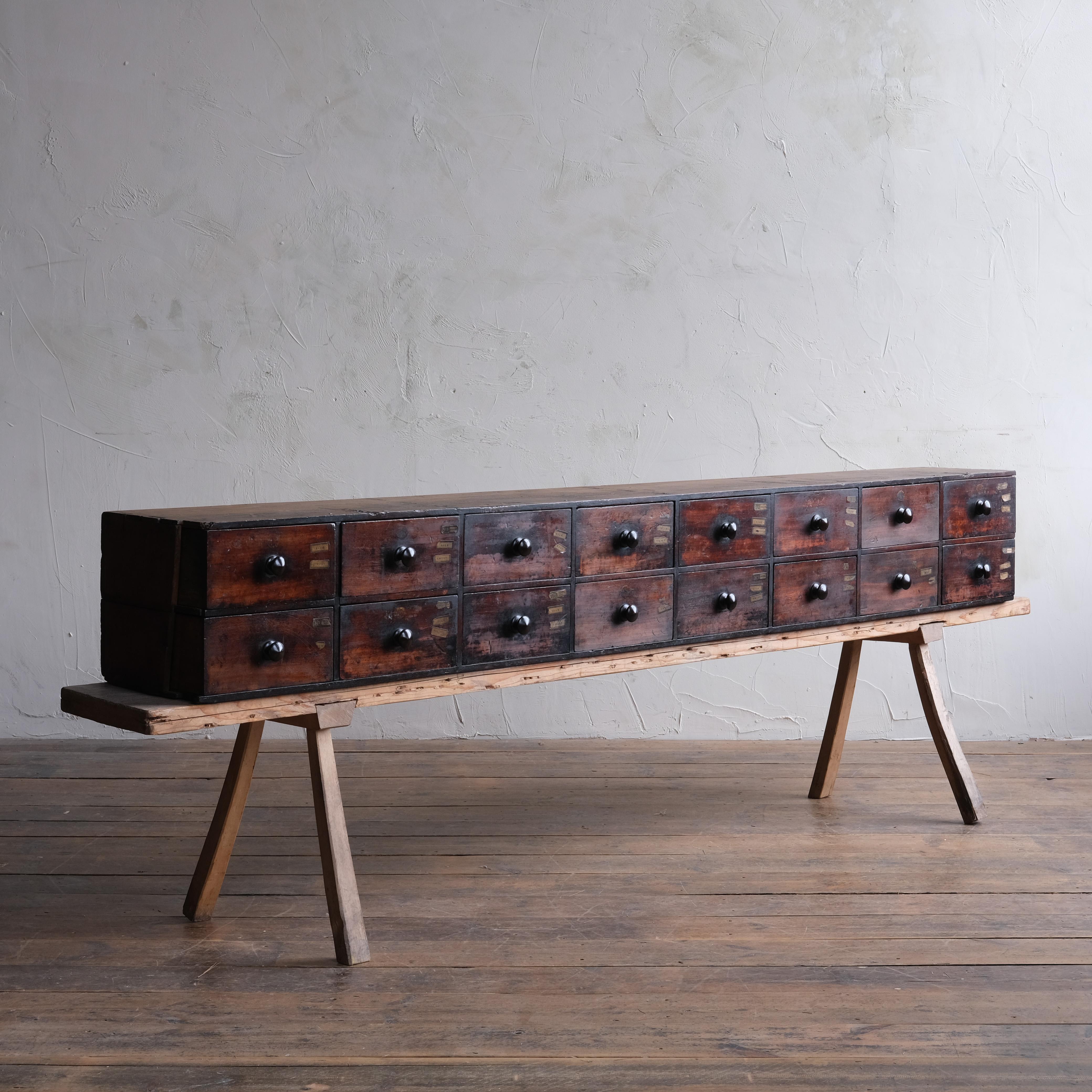 A very attractively worn mid 19th century bank of apothecary drawers. The mahogany drawers encased by a long dovetailed pine carcass and its original back. A well used piece that does show it age with various losses such as the sides and a few