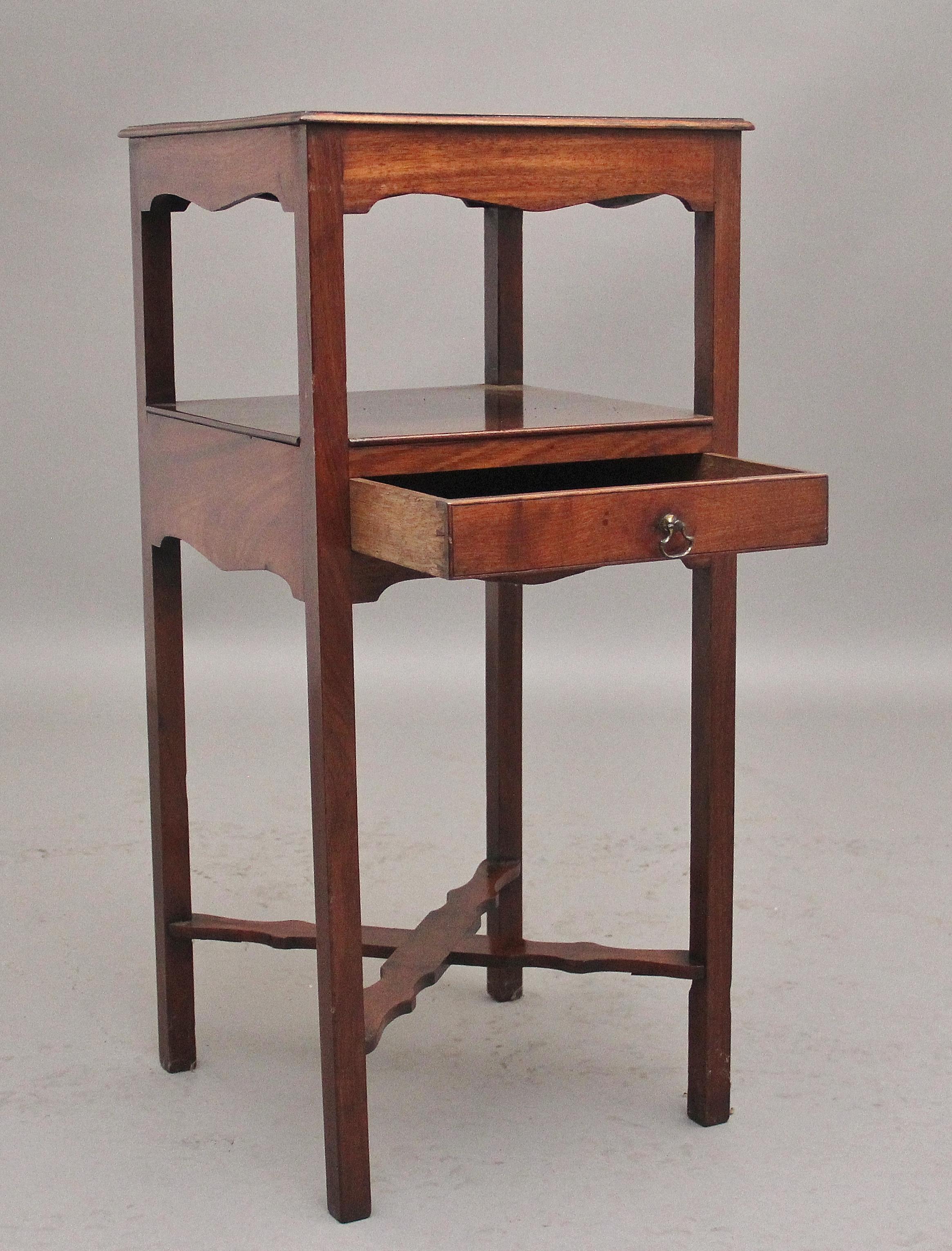 Early 19th Century mahogany bedside table, the top tier having a shaped boarder and frieze, the middle tier having an oak lined frieze drawer with original brass handle, standing on square legs united by shaped cross stretcher.  Circa 1830.