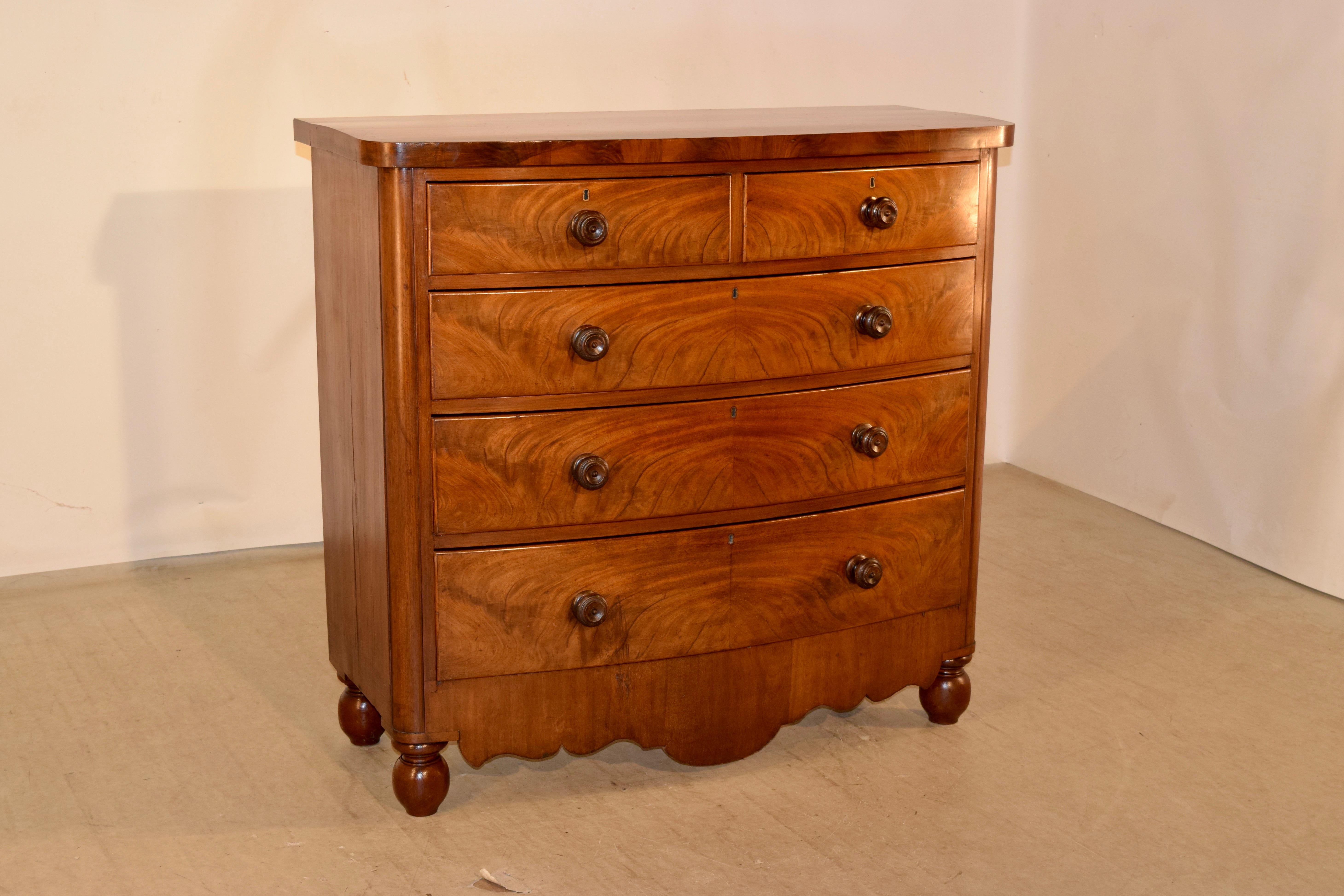 19th century bow front chest from England made from Mahogany. The top is wonderfully grained, and follows down to simple sides and two over three drawer configuration in the front. The drawers have lovely figuring as well, and are over a hand