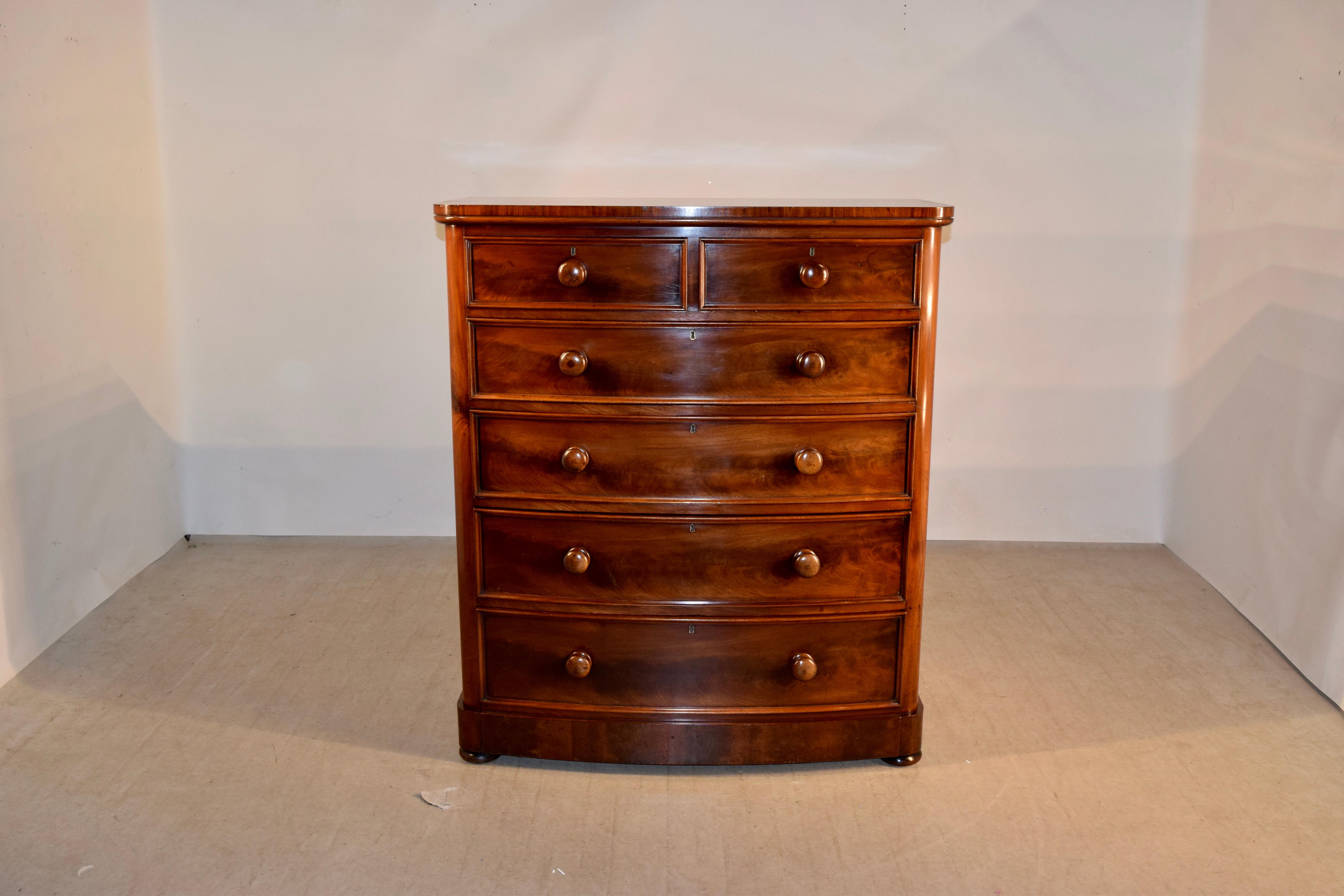 19th century mahogany bow front chest of drawers from England. The top is beautifully figured and follows down to simple sides and two drawers over four drawers. The bottom drawer is very deep and continues all the way to the bottom of the case
