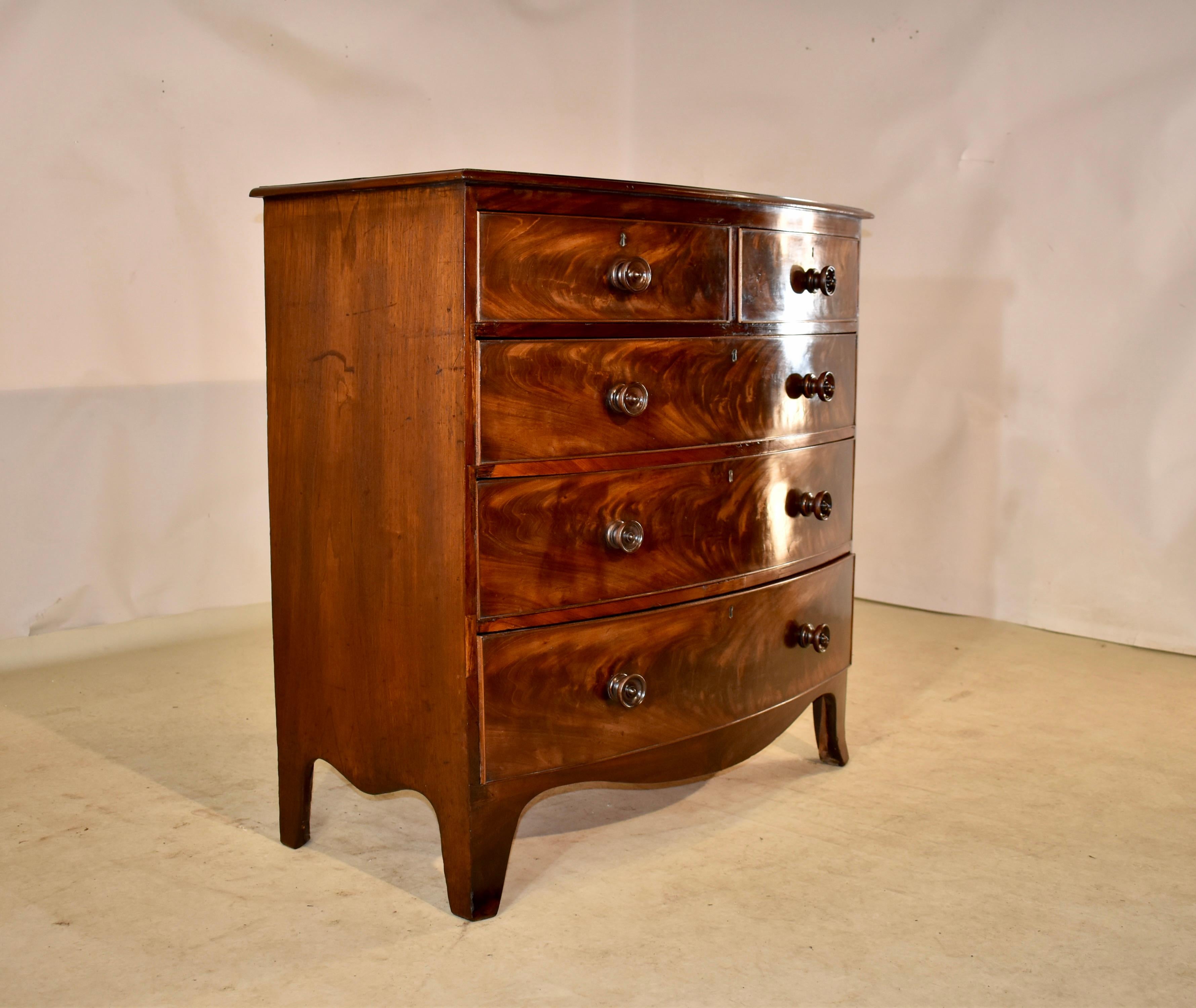 19th Century mahogany bow front chest of drawers from England with a nicely grained top, which also has a beveled edge, following down to simple sides and a bow front with two drawers over three drawers. The drawer fronts have gorgeous flame