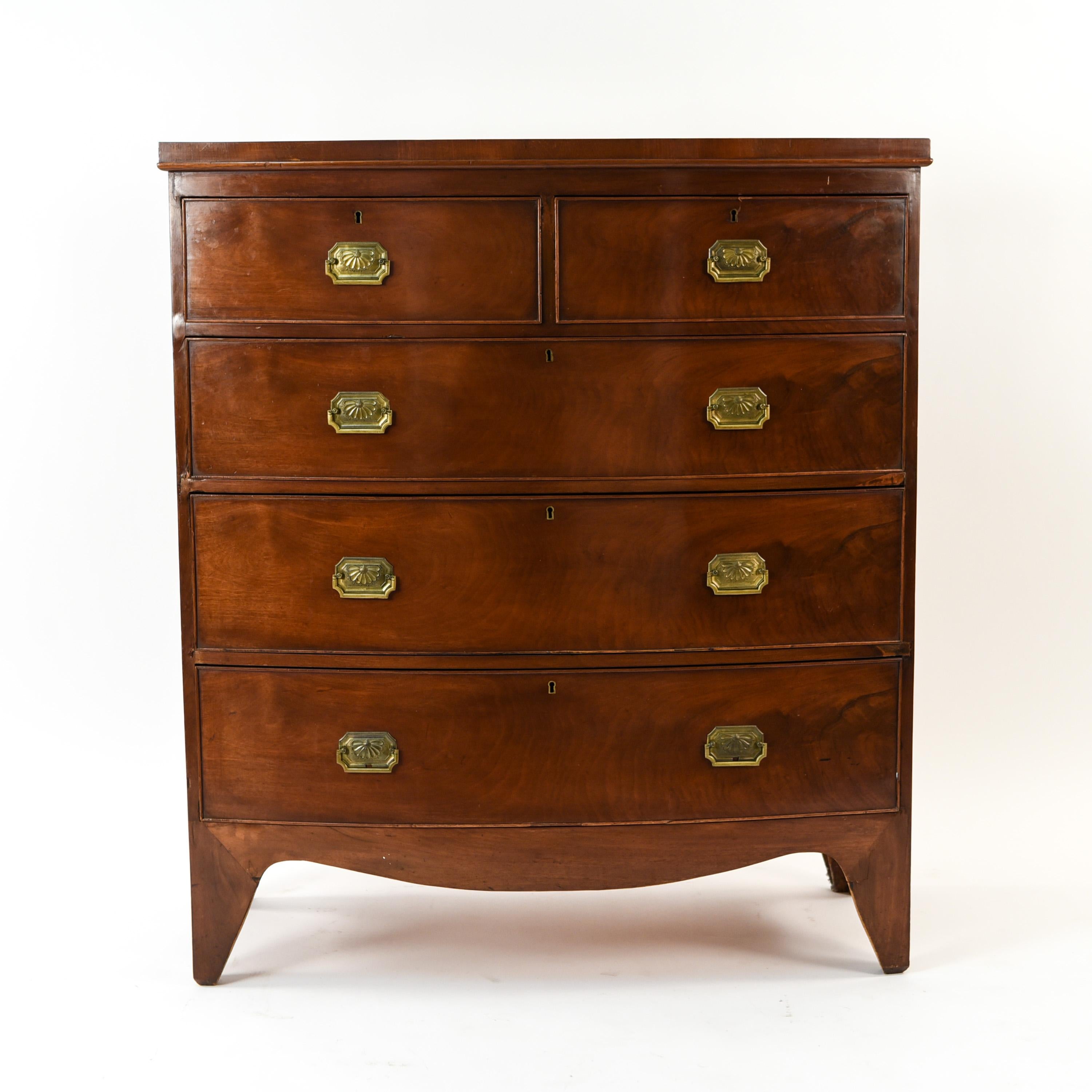 This 19th century English Regency period chest of drawers features five drawers in a two-over-three drawer bow front design and is crafted of quality mahogany wood. This handsome antique chest has traditional hardware and an attractive, pleasing