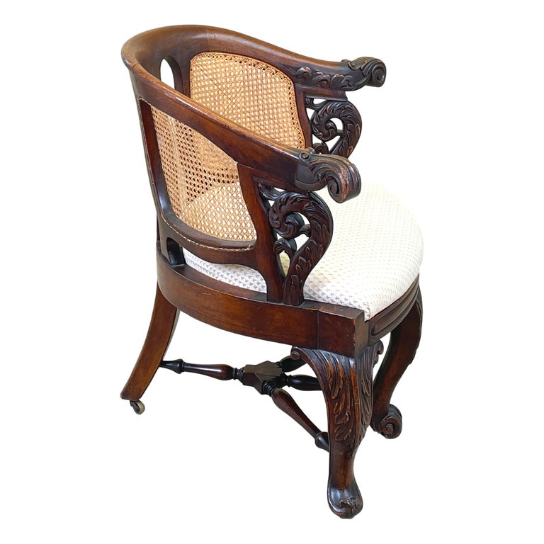 A very attractive mid 19th century mahogany Bürgermeister
desk chair, probably Dutch, having curved back with caned
panels and carved scrolling arms over upholstered seat raised
on elegant carved cabriole legs united by turned
cross