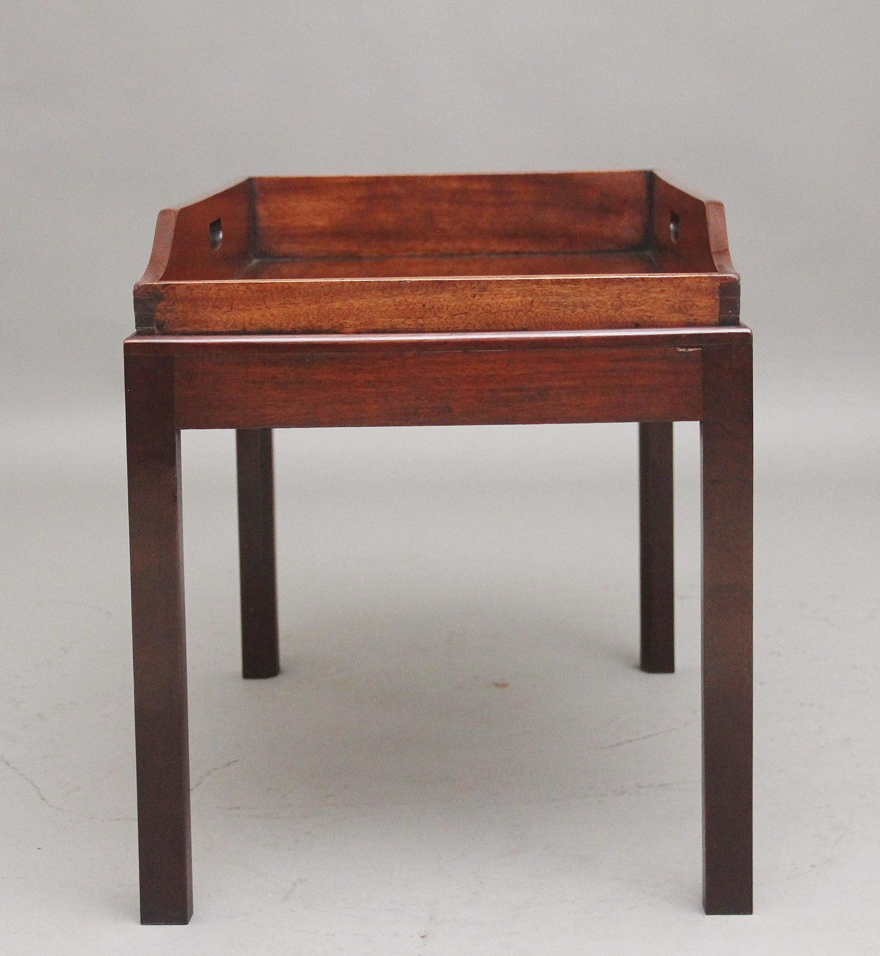 A lovely quality early 19th Century mahogany butlers tray on stand, the rectangular shaped tray with a surround gallery three quarters raised and with two fret cut carrying handles, supported on a later stand with square tapering legs.  Circa 1830.
 