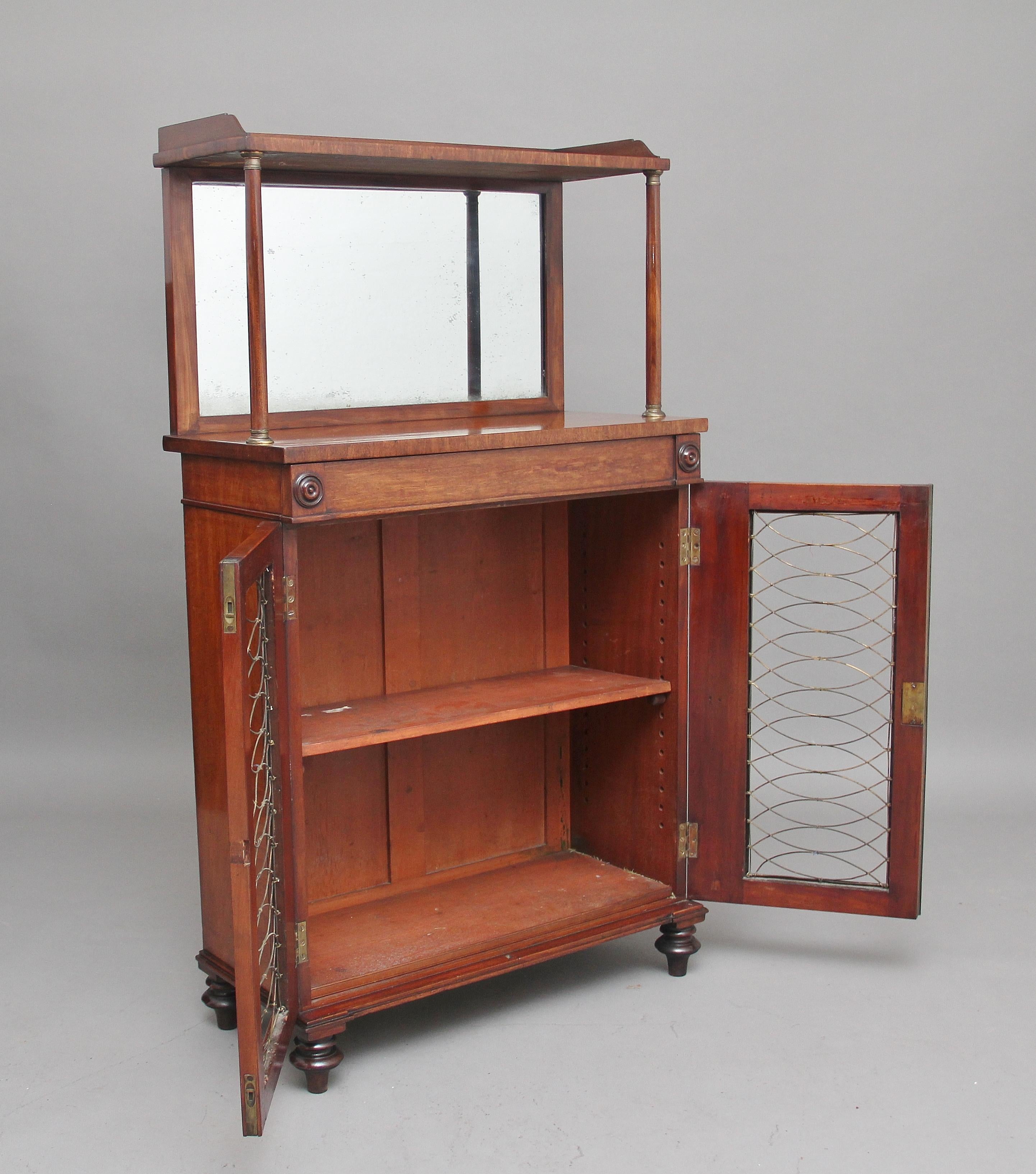 19th century mahogany cabinet of nice proportions, having a mirror back and shelf supported by turned columns, the shelf decorated with a gallery running along the back and sides, the cabinet having a single frieze drawer decorated with carved