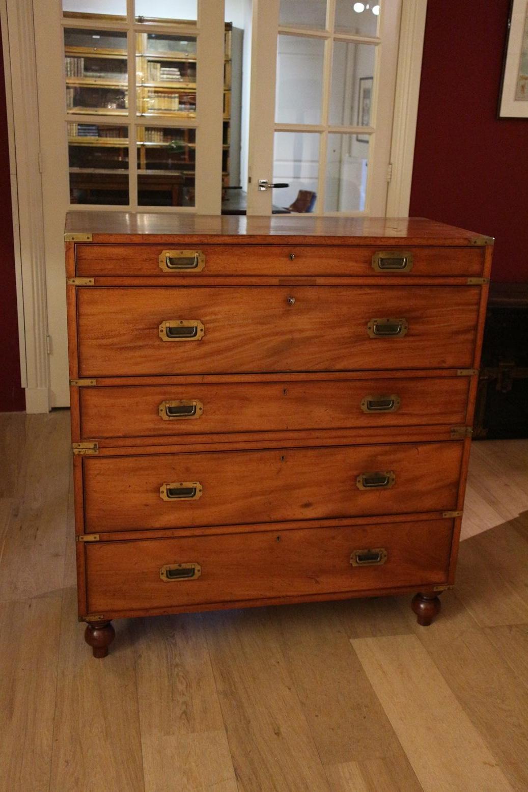 Special antique mahogany Campaign chest of drawers with secretaire. Entirely in beautiful original condition. The Campaign chest of drawers consists of 2 parts, flat drawer pullers, brass corners and the original removable legs. All this is