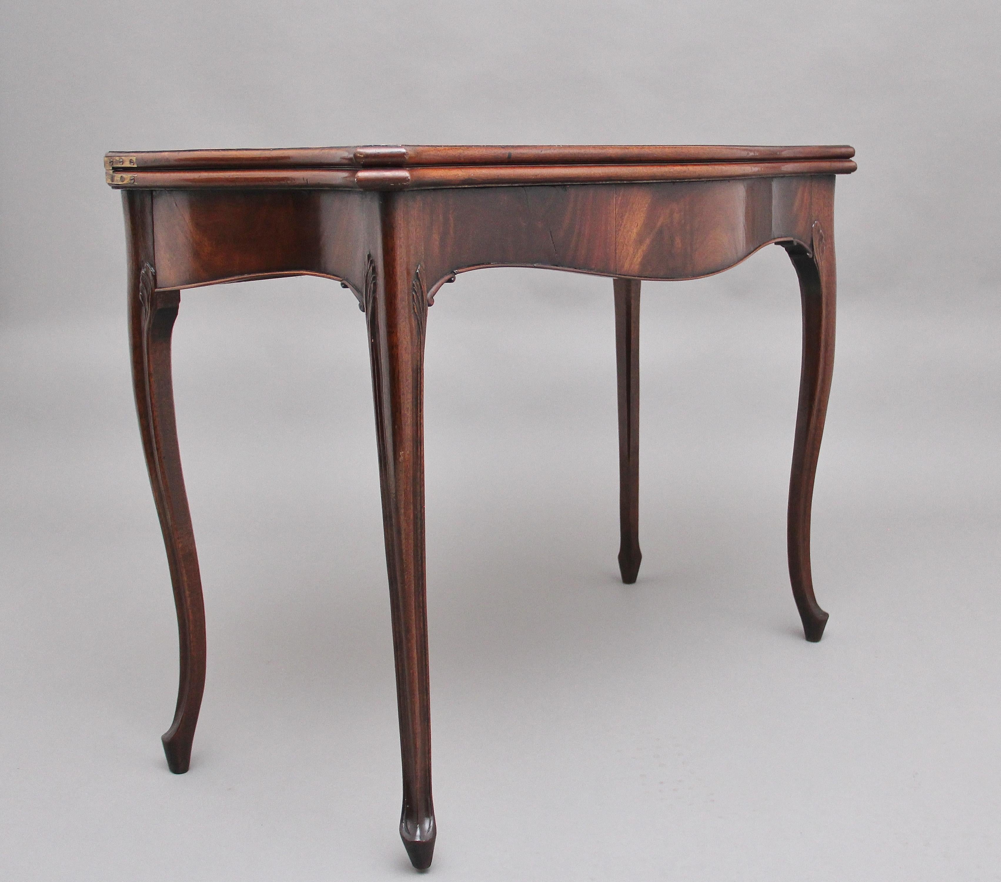 Early 19th century mahogany card table, the moulded edge shaped top opening to reveal a green baize playing surface, the shaped frieze below with carved leaf decoration at each side, supported on slender cabriole legs. Circa 1810.