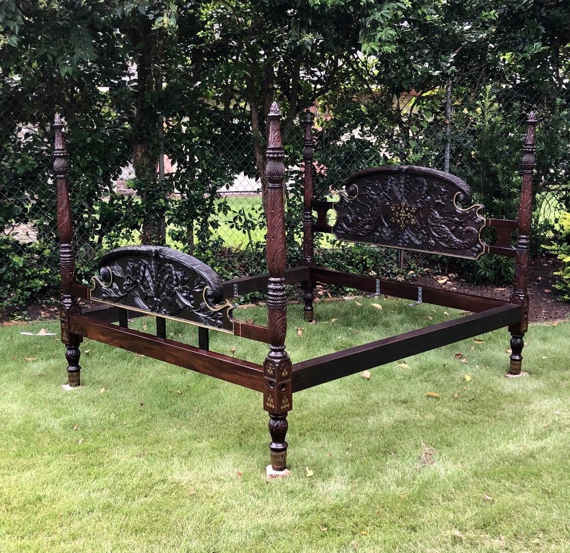 This elegant Caribbean mahogany bed was constructed in the 19th century. This rare West Indies Bedstead exhibits a scarce and desirable hand carved headboard and footboard framed in pierced brass inlay. The headboard is finely carved with a