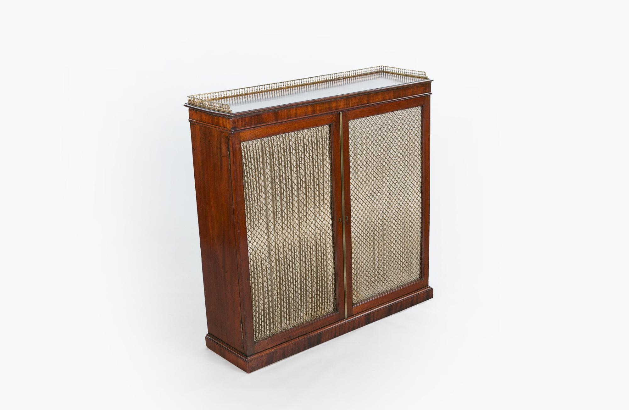 19th century mahogany chiffonier cabinet, the moulded top with pierced brass gallery of rectangular form raised over two lined brass grill cupboard doors with reeded brass closing slip opening to reveal shelved interior supported on plinth base.