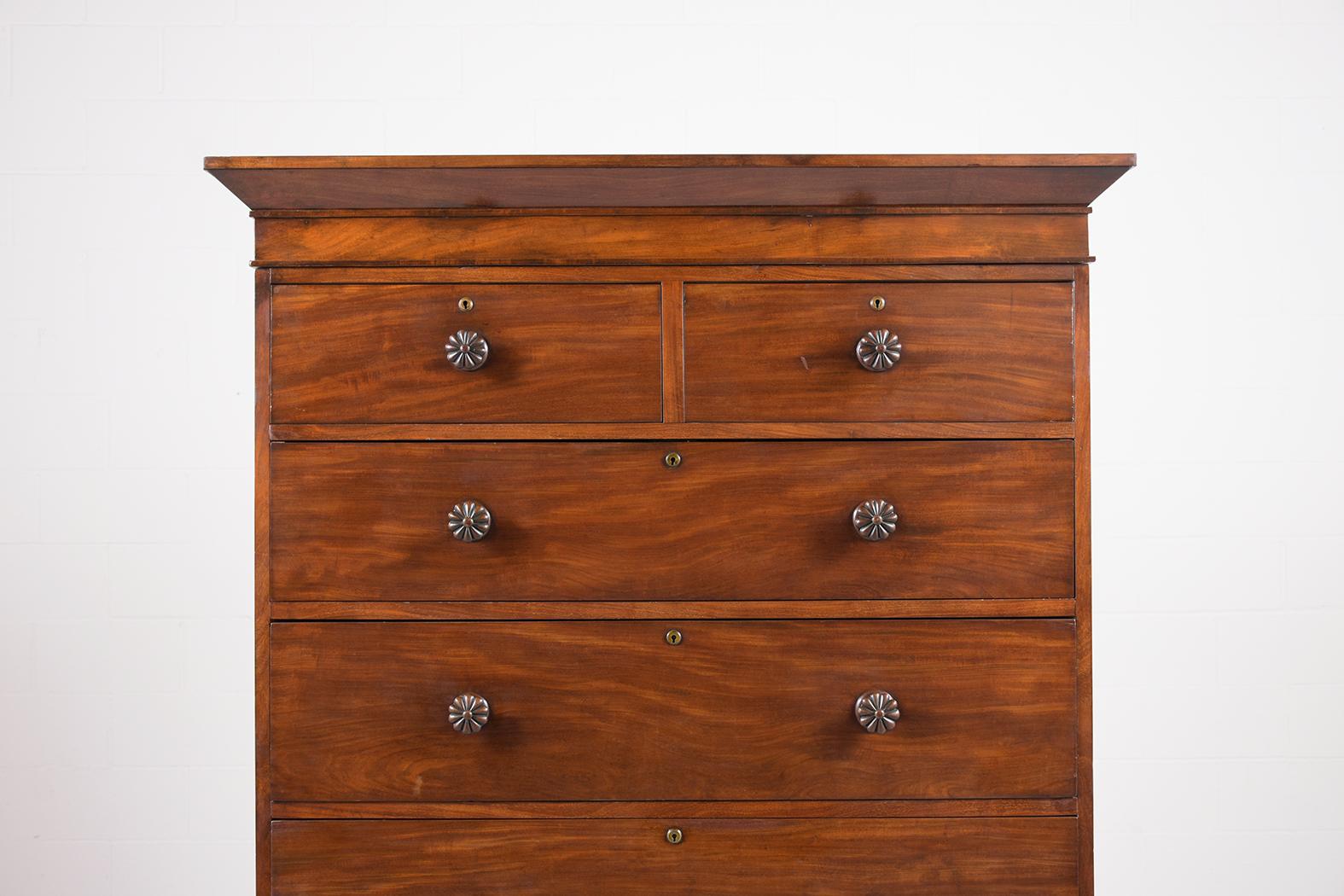 Step back in time with our exquisite 19th-century tall chest of drawers, which has been skillfully restored to its former glory by our dedicated team of craftsmen. Made from rich mahogany wood, this antique dresser radiates with its original dark