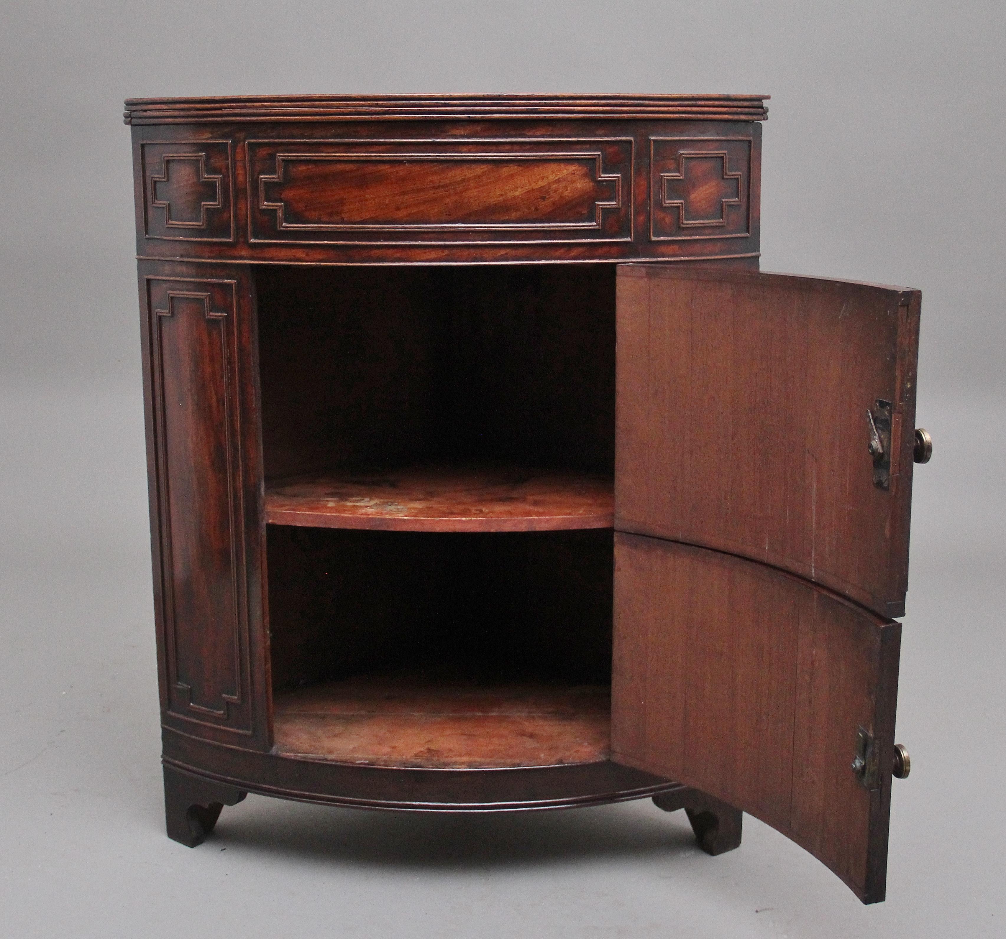 19th Century mahogany corner washstand, the front of the cabinet having decorative applied moulding , two hinged doors opening to reveal a single fixed shelf, the hinged lift up top to opening to act as a decorative splash back and shelf, supported
