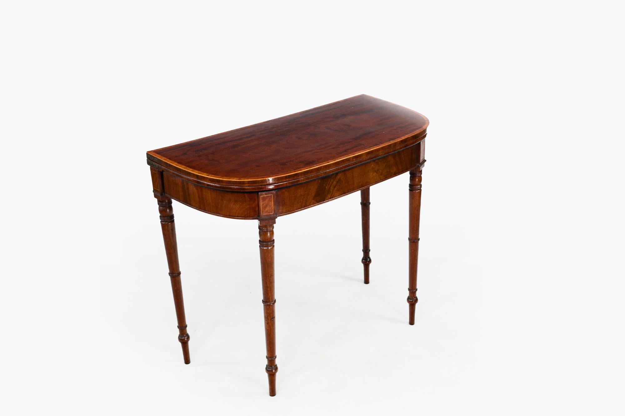 Table à cartes en acajou du 19e siècle. Le plateau à charnières en D s'ouvre pour révéler l'intérieur en baize rouge et est surmonté d'un tablier mouluré et incrusté qui se termine par des pieds tournés.