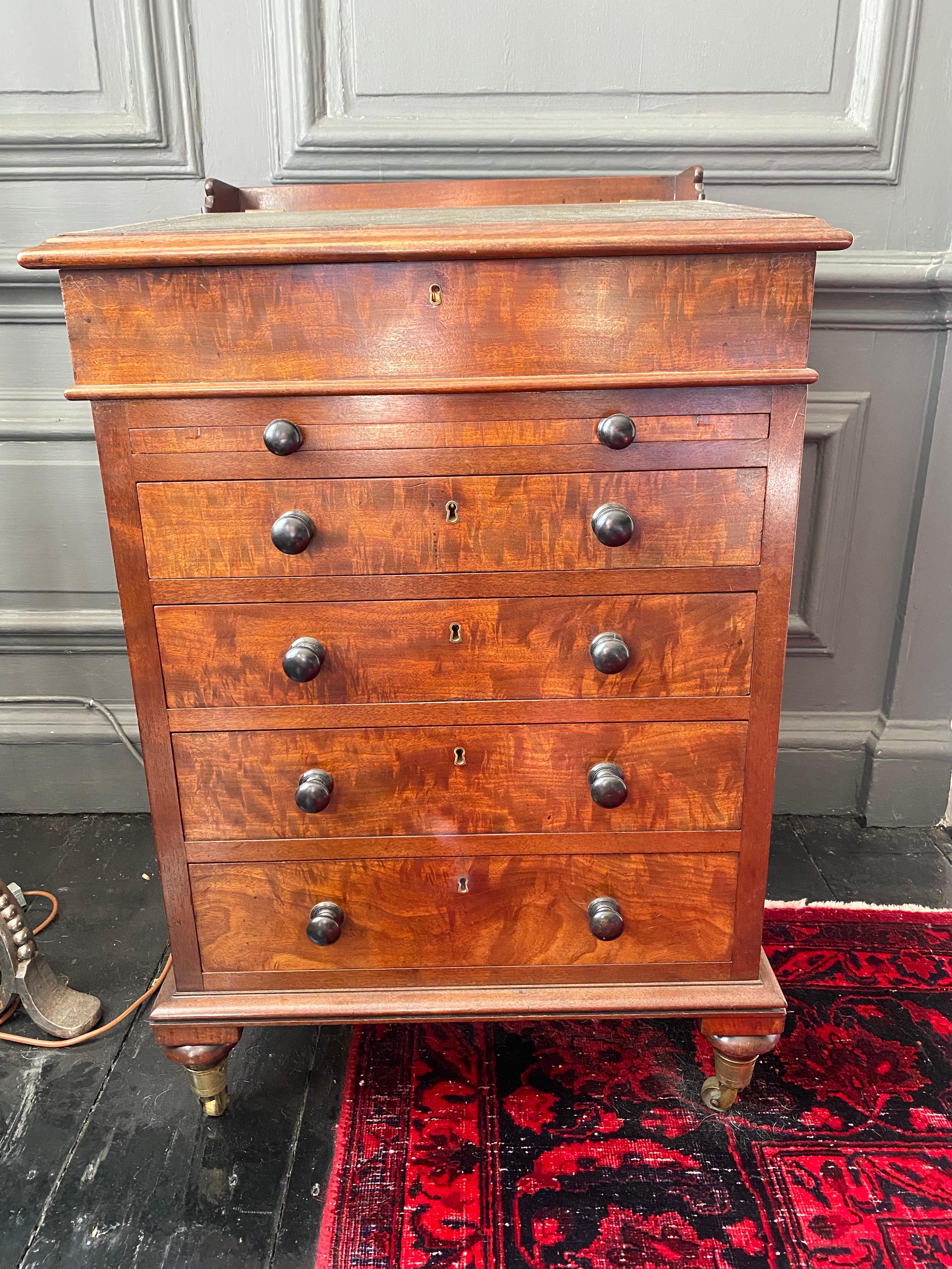 A Fine quality 19th century Davenport in mahogany. The swivel pivoting top section with tooled leather writing slope, with secret pop out side drawer actuated by pull the internal drawer knob, five graduated drawers all fitted with turned knobs,