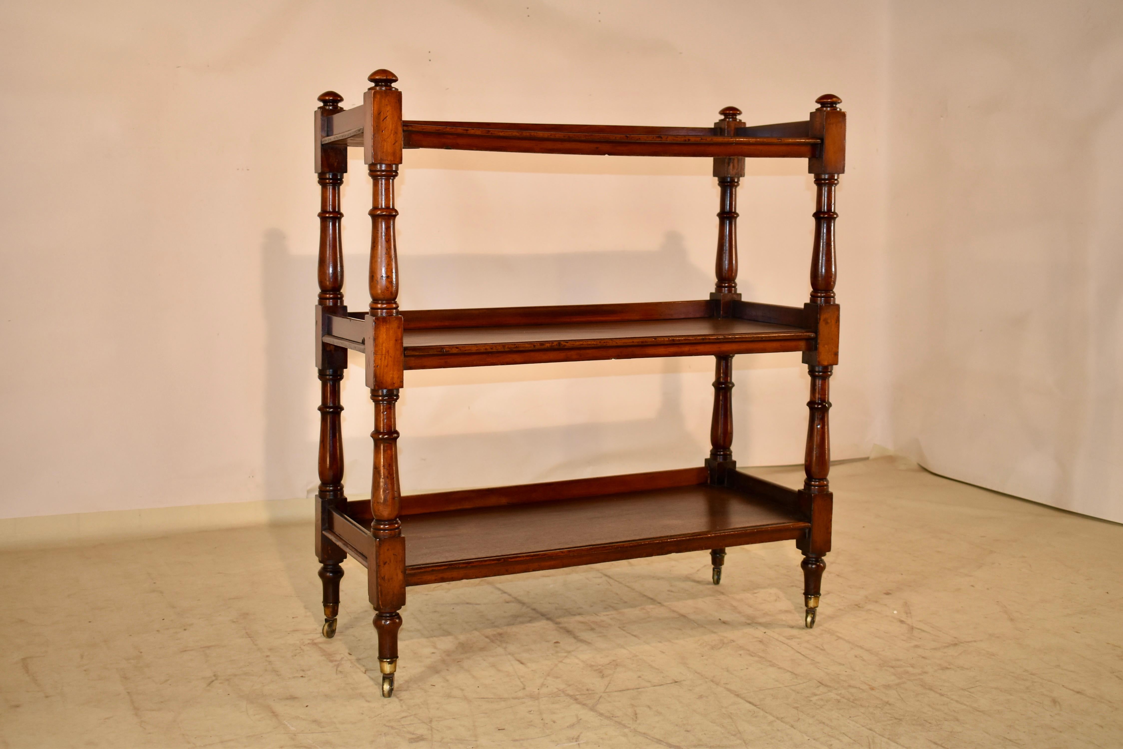 19th century English dessert buffet made from Mahogany.  The piece has finials at the top over three shelves, all with galleries on three sides.  The shelf supports are hand turned.  The aprons beneath the shelves have signs of wear, which are