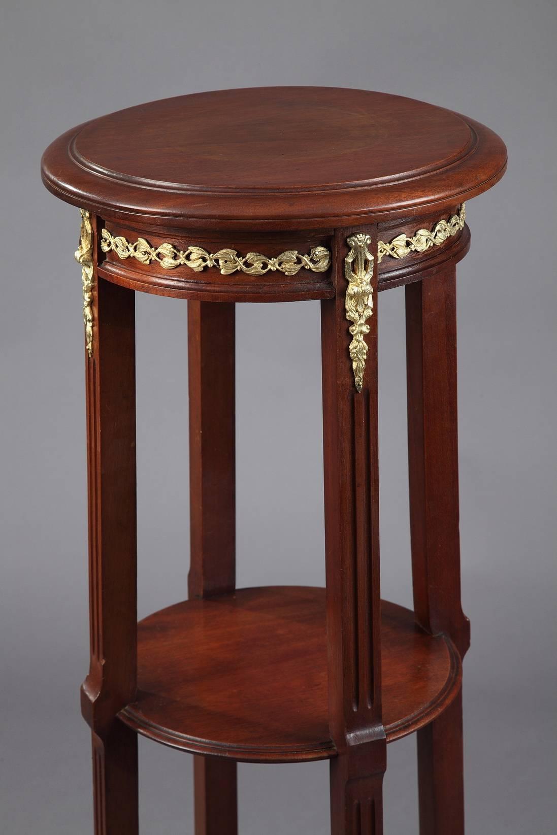 Display column in mahogany, composed of three display plates with round sections. The set rests on four curved feet decorated with gilt bronze foliage. The upper plate is embellished with foliate interlace. Late 19th century period.

circa