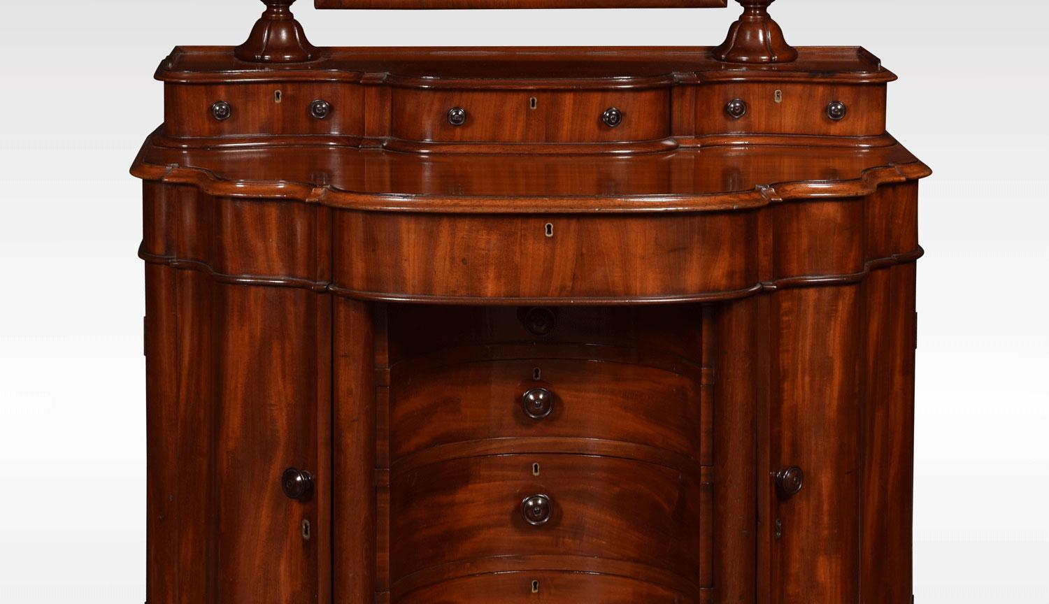 19th century mahogany dressing table, the raised superstructure having two turned fluted columns, supporting the original mirror plate, above three short draws. The shaped mahogany top with moulded edge having single freeze draw below. The dressing