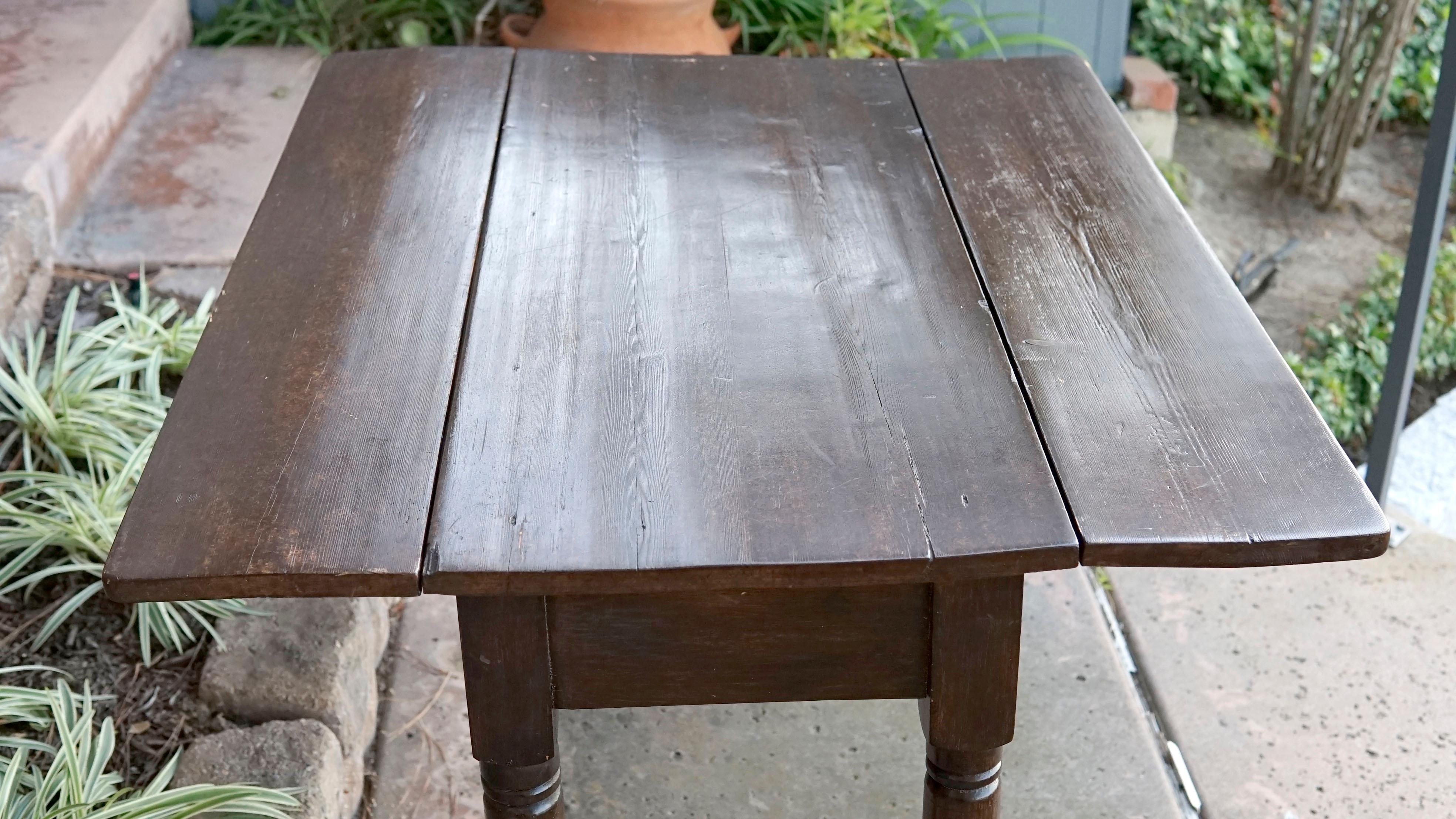 The dark chocolate tone and the patina of the mahogany make this table irresistible. It is a cllassical style, mahogany drop-leaf table from New England, manufactured in the late 19th century. It is unmarked. 
The rectangular top has a straight