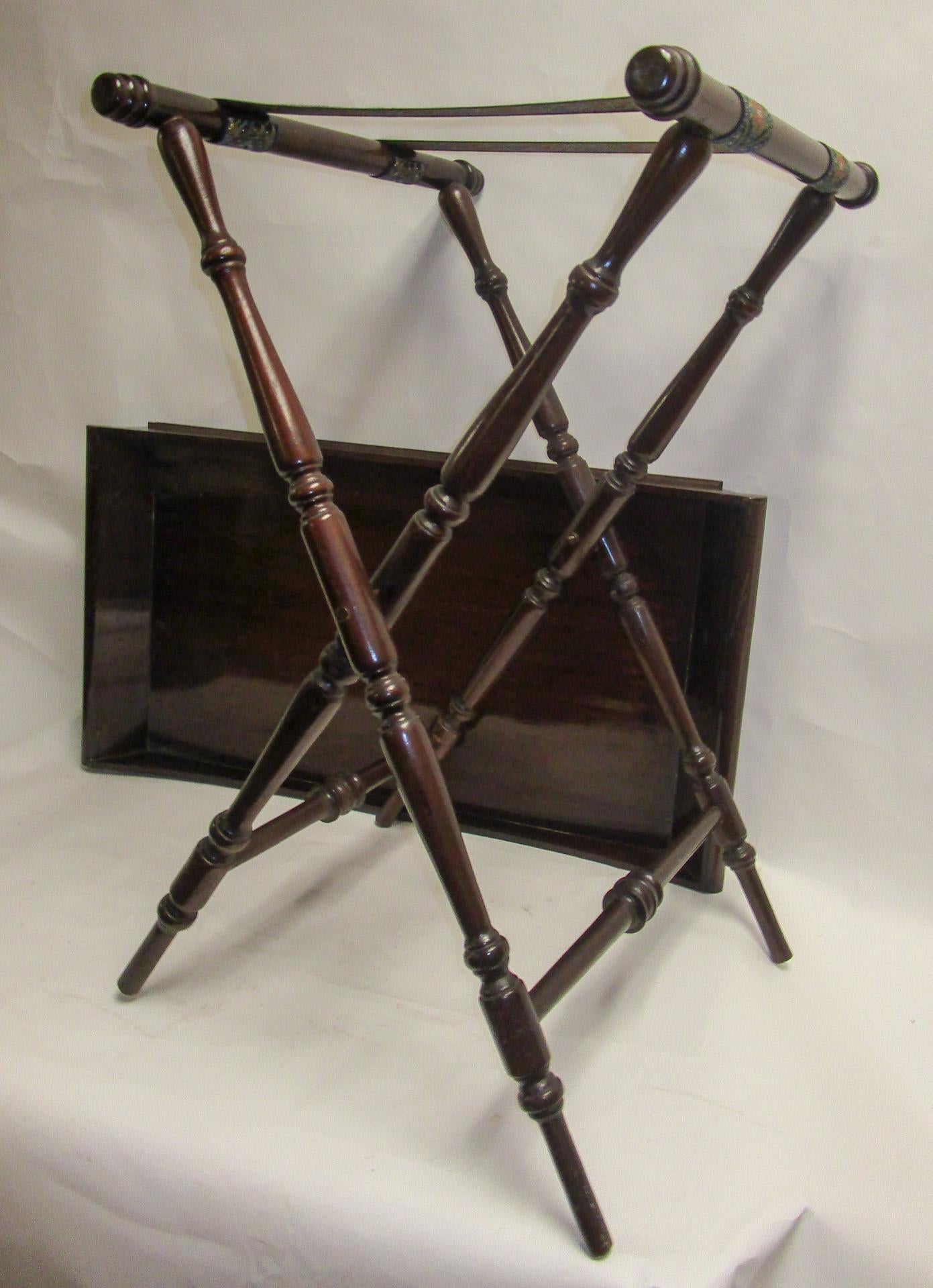 Regency Period mahogany butlers tray on Stand featuring a rectangular shaped tray with a surround gallery. A slight slope terminates into handles for easy access. On folding X frame stand with heavy woven straps that accommodate the tray.
These