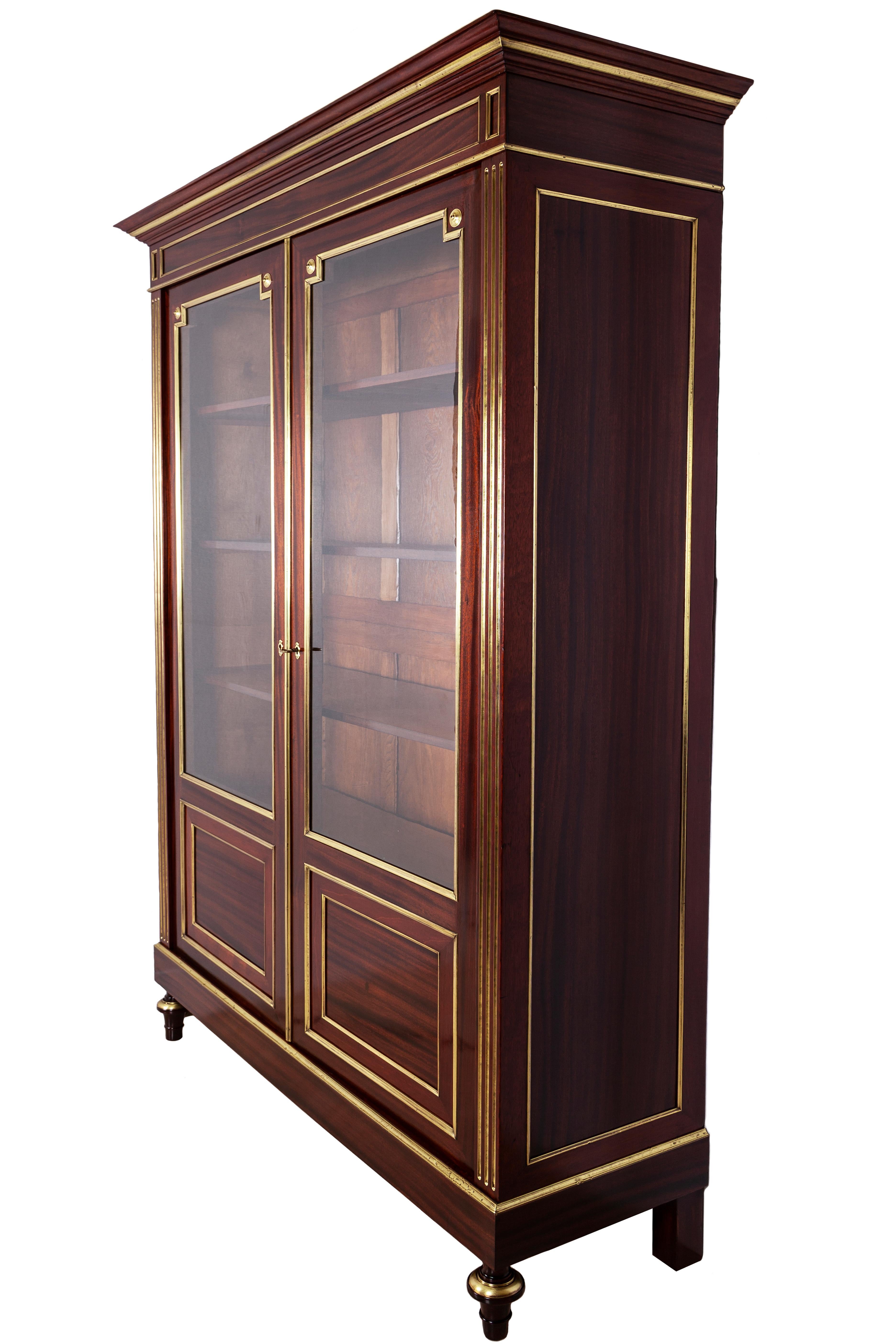 A very fine second Empire bookcase or display cabinet in mahogany. It has two doors with the original glass.
This beautiful bookcase is embellished with frames and moldings in brass sheet.
On the inside, it is composed by four adjustable shelves.