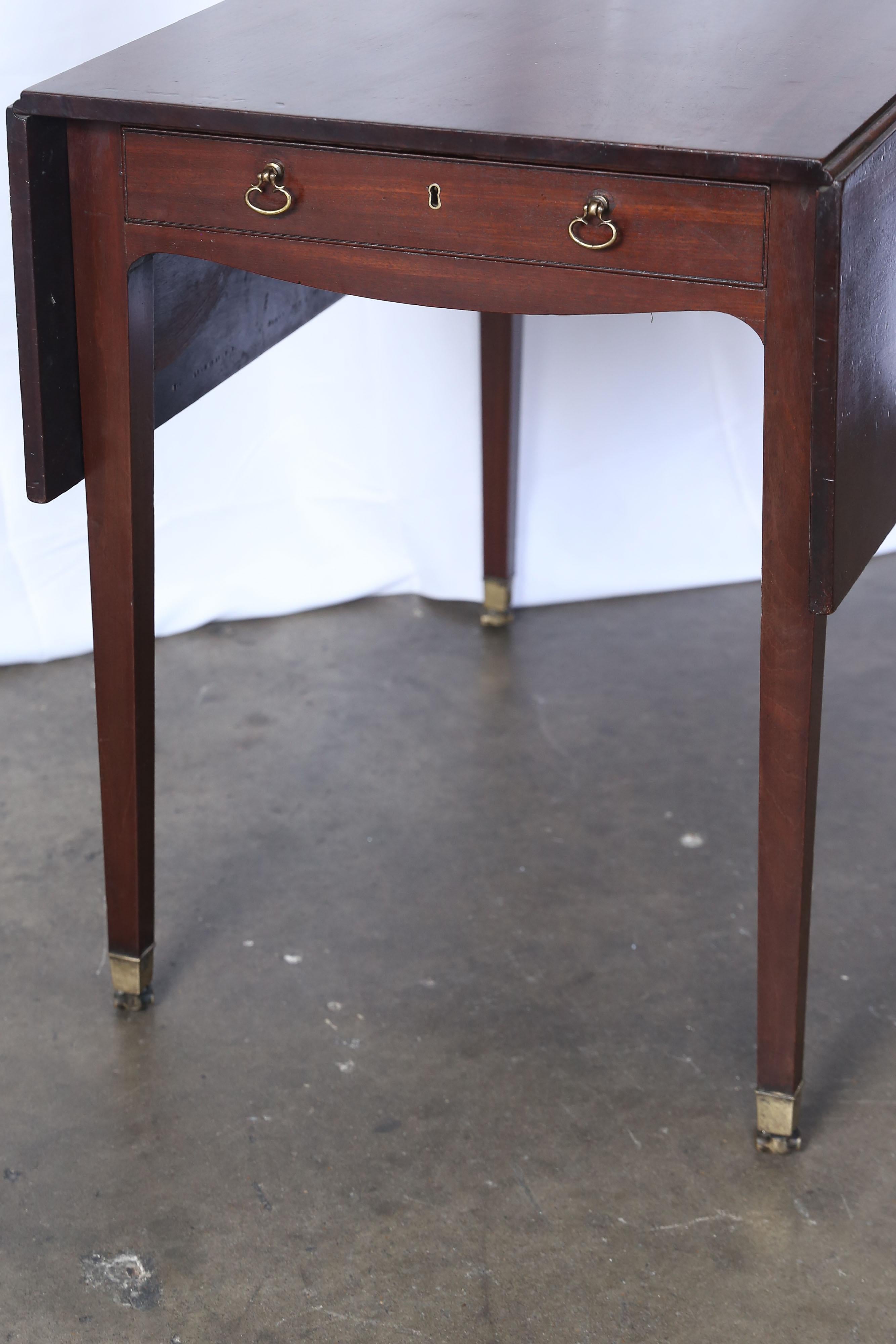 Early 19th century mahogany Pembroke Table in the Georgian style. All four legs have brass caps and are on wheels. When opened the table-top is 42.25