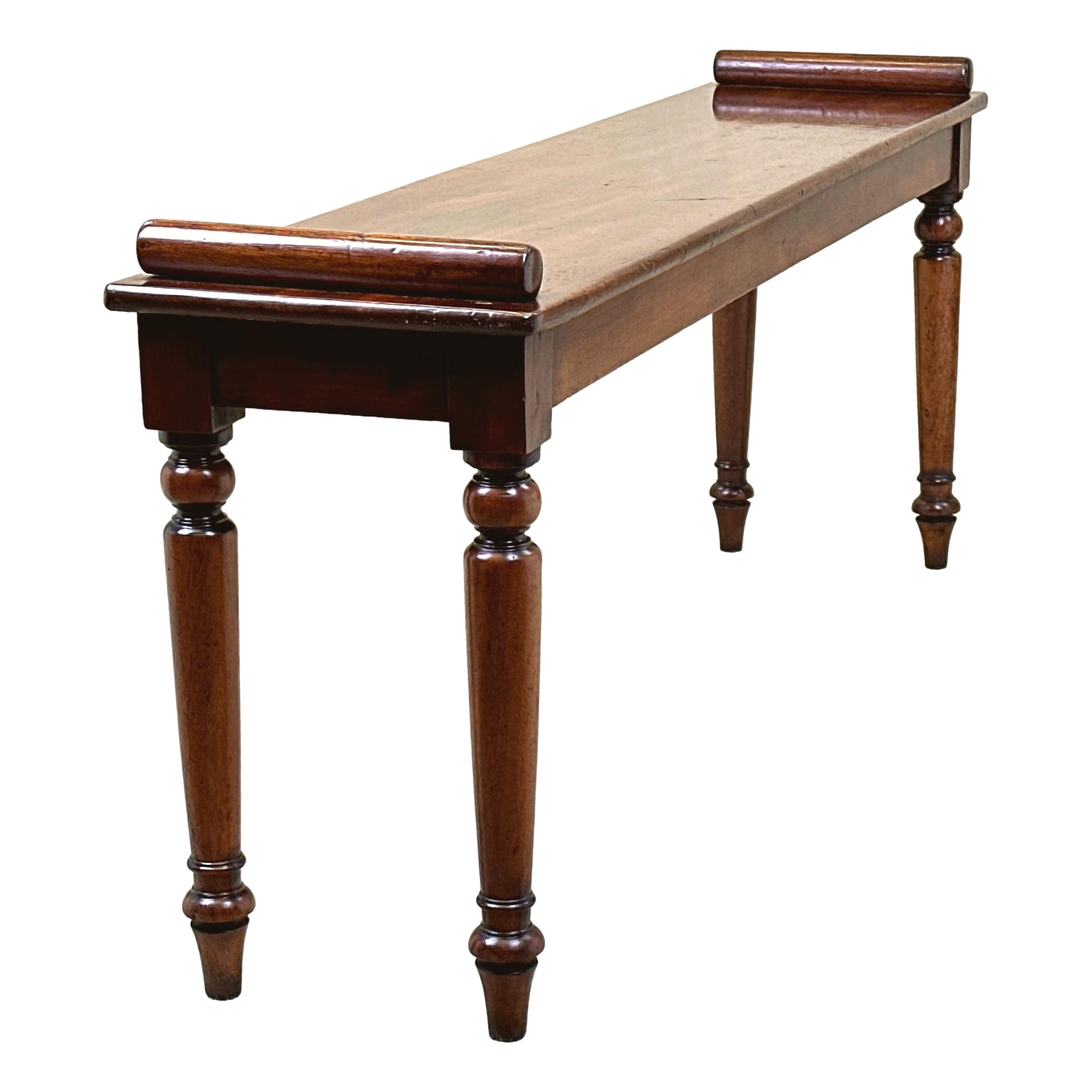 A Very Good Quality Mid 19th Century mahogany window seat, Or Hall Bench, Of Elegant Narrow Proportions, Having Well Figured Rectangular Top With Applied Turned Roll To Each End, Raised On Four Fine Turned, Tapering Legs.


Hall benches from the