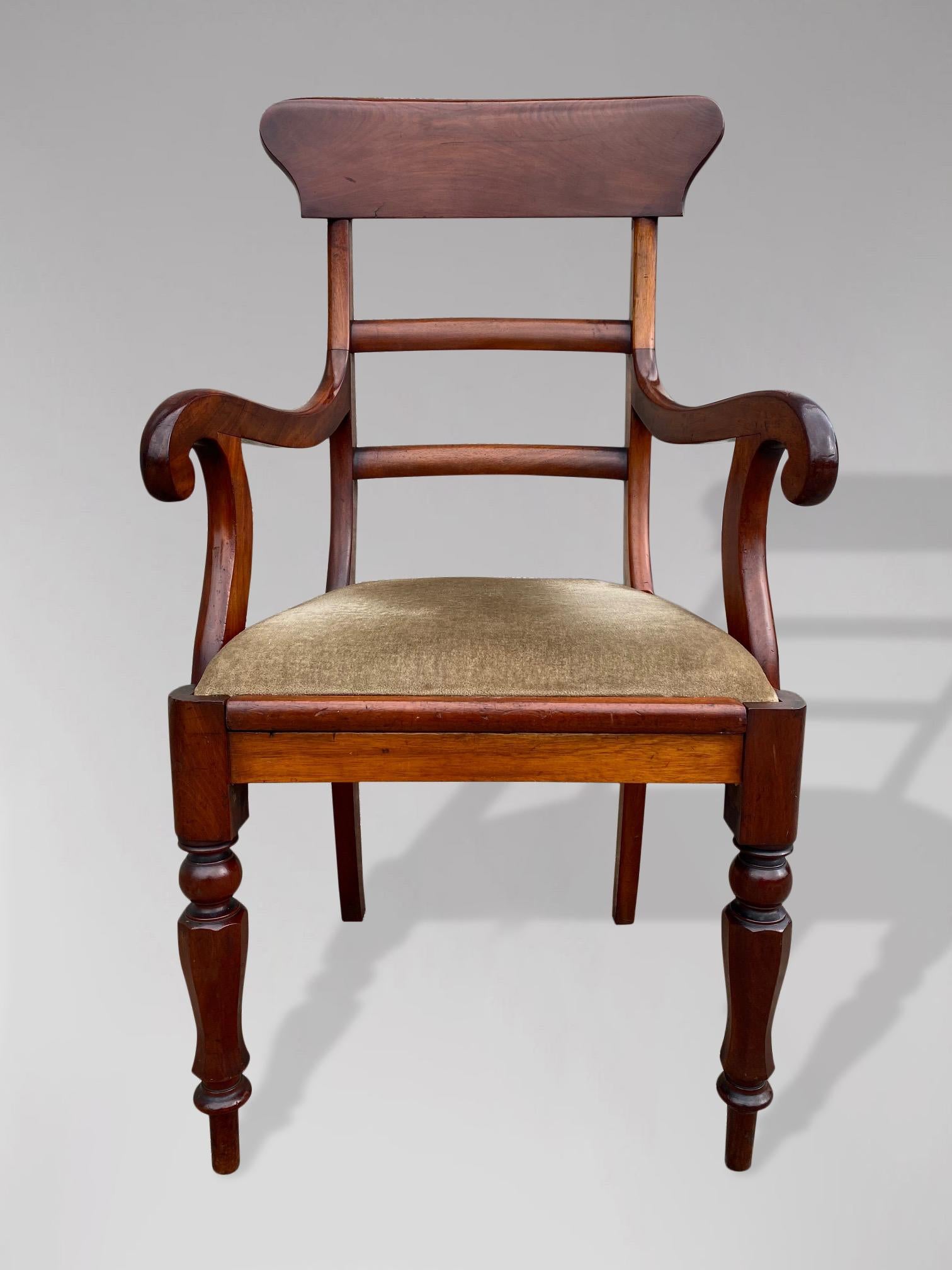 A good quality William IV period solid Cuban mahogany high bar back desk armchair having a quality shaped top back rail, with shaped open arms standing on turned tapering legs to the front and out swept rear legs. Having a drop in upholstered seat.