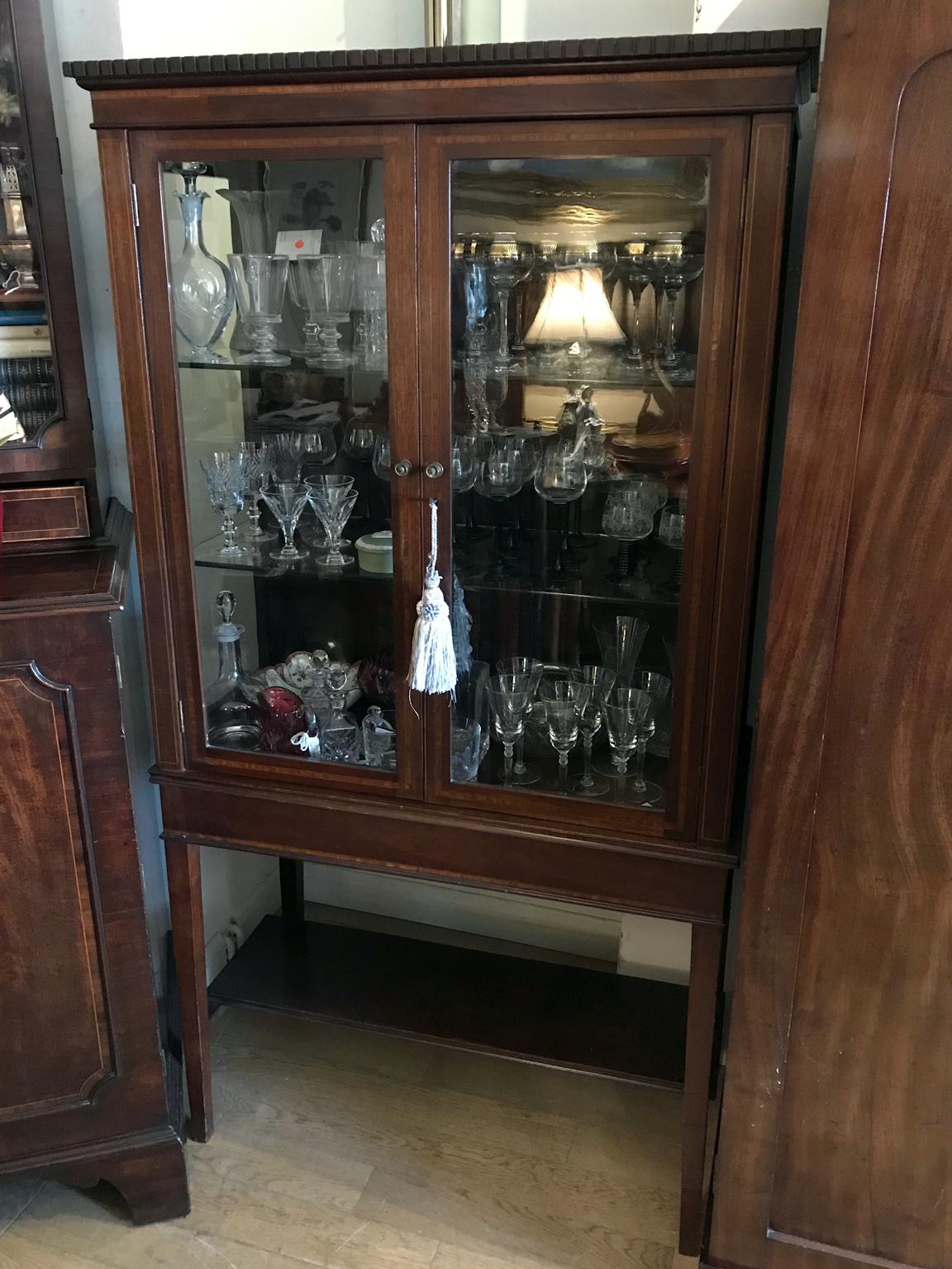 19th century mahogany inlaid Victorian display cabinet with three glass shelves and working key on four legs and an under-tier shelf below,

circa 1890

Dimensions:
Height 67 inches - 170 cms
Width 35.5 inches - 90 cms
Depth 17 inches - 44
