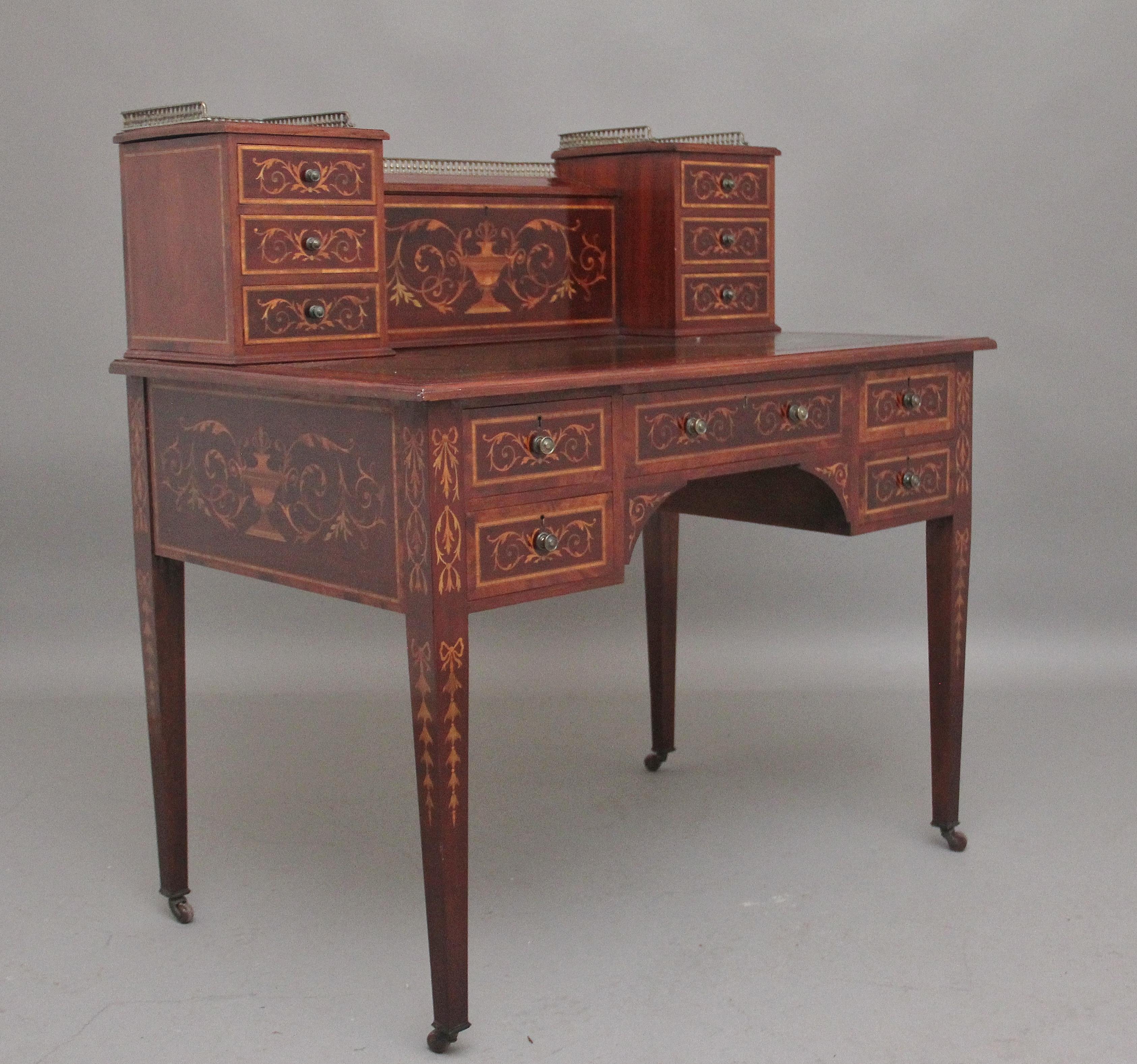 A superb quality 19th Century mahogany inlaid writing desk, the super structure comprising of three mahogany lined drawers either side with the original turned brass knob handles and ornate floral inlay on the drawer fronts, a stationary compartment