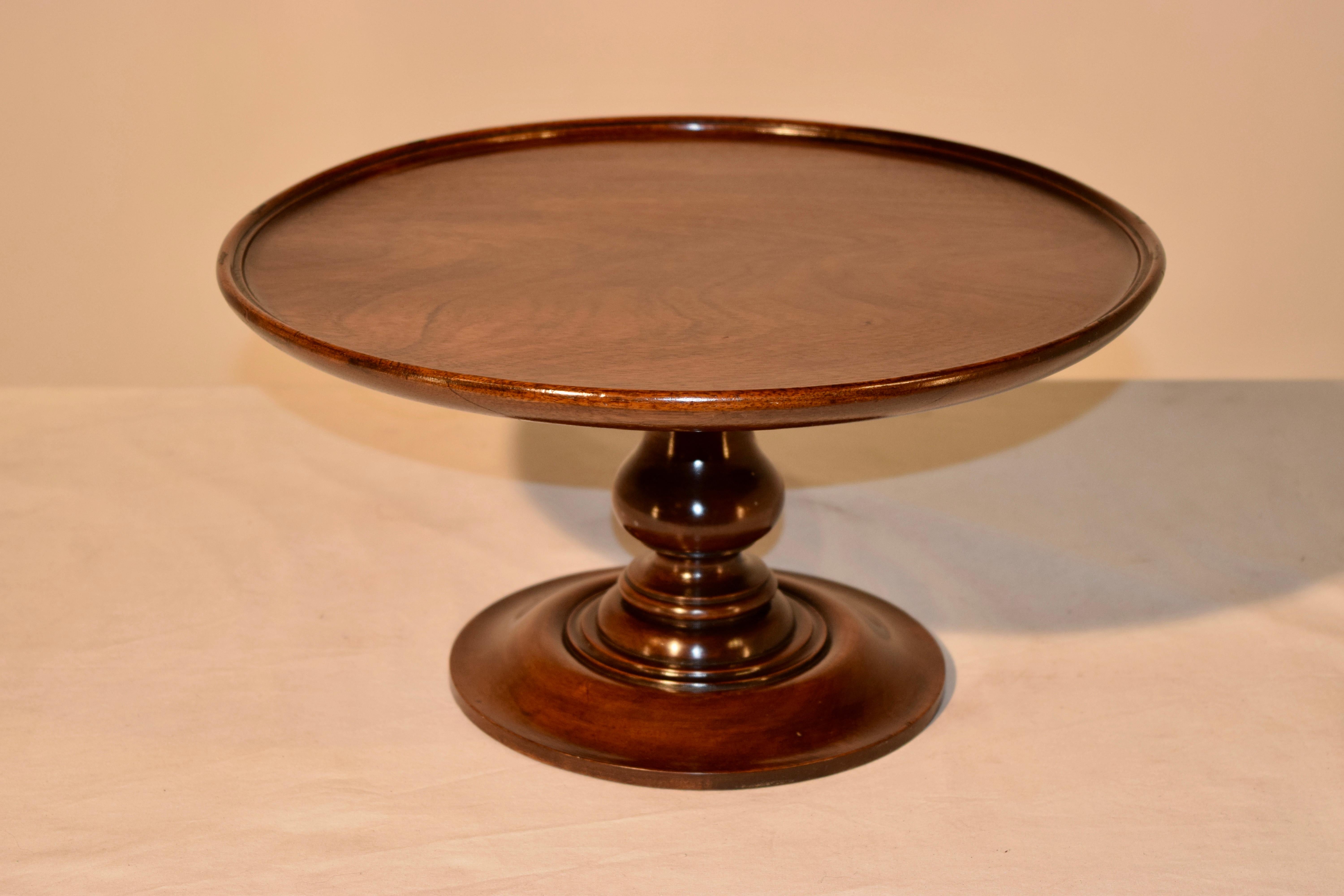 19th century English Lazy Susan made from mahogany with a dish shaped top supported on a nicely hand-turned pedestal base. The top has slight warping from age.