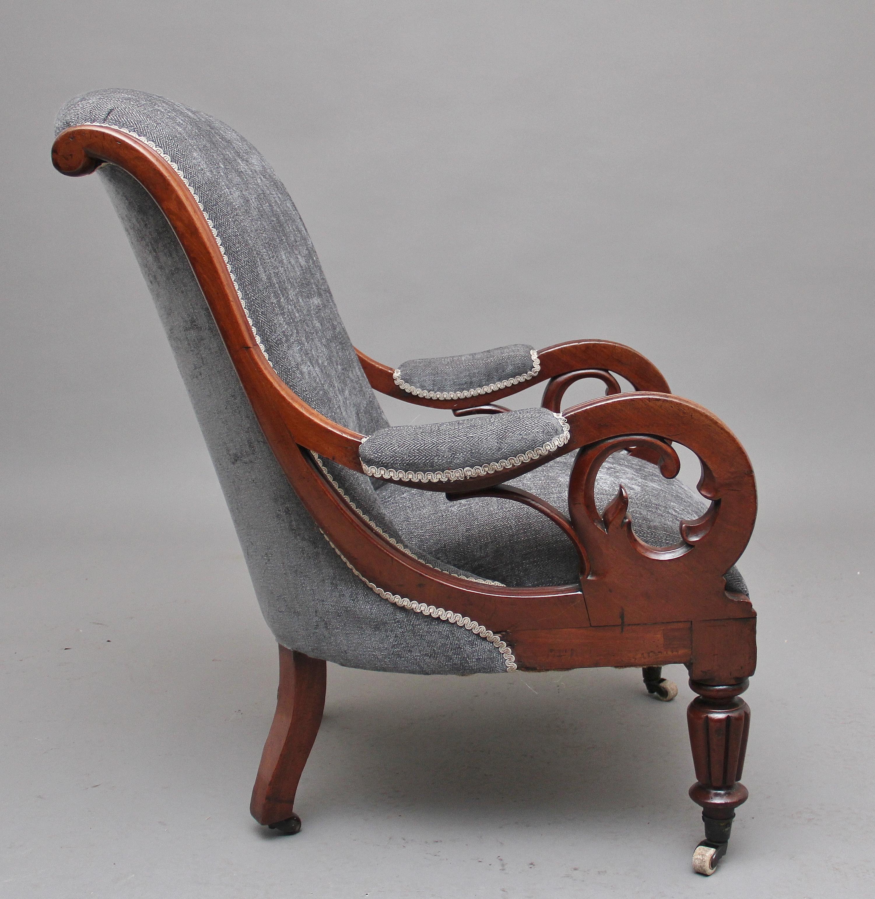 19th century mahogany library / open armchair upholstered in a grey fabric, the shaped and scroll back with padded arms, wonderful shaped arm supports with Gothic features, stuffover upholstered padded seat, supported on rear outswept legs and
