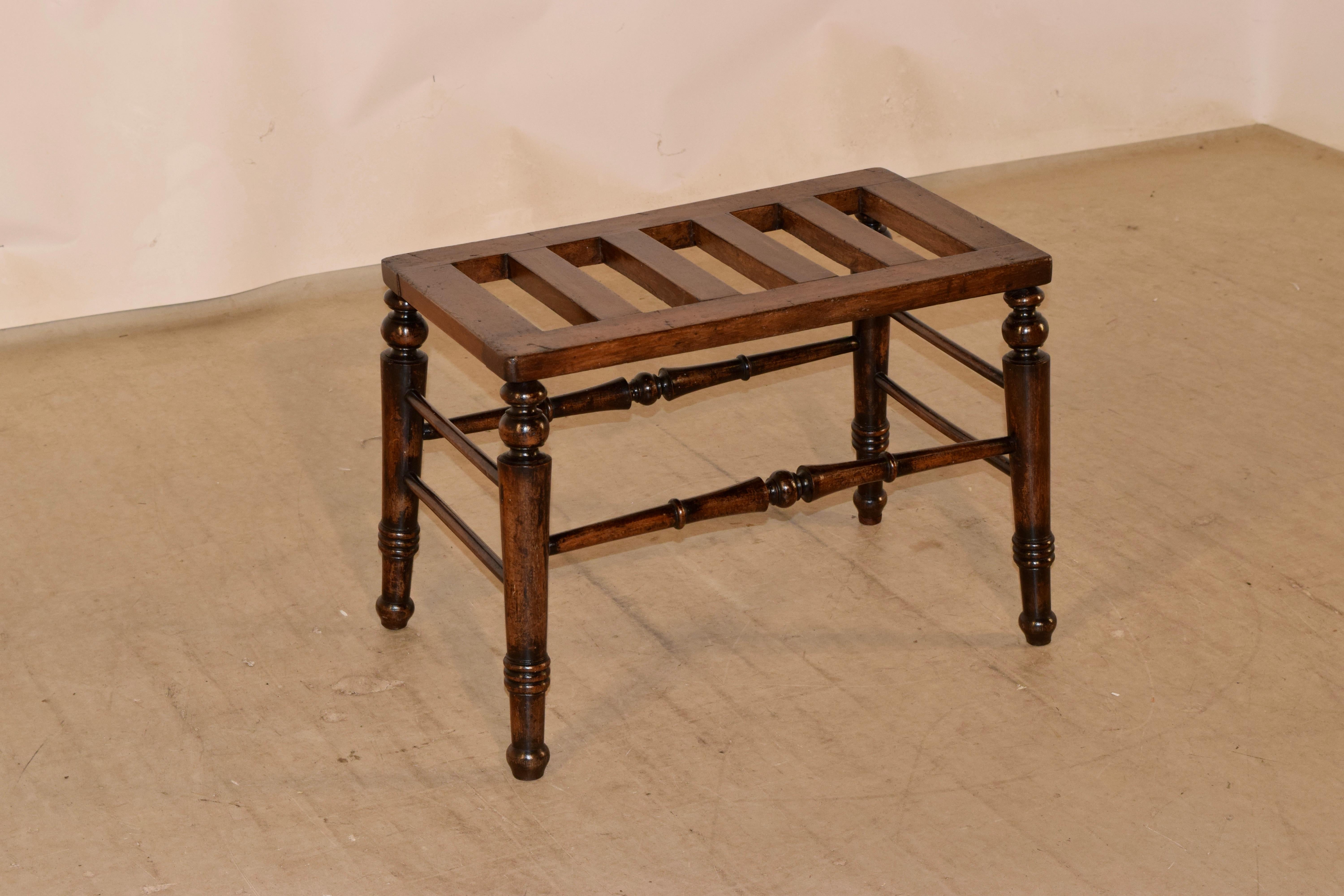 19th century mahogany luggage stand from England with a slatted top supported on hand turned splayed legs, joined by turned stretchers.