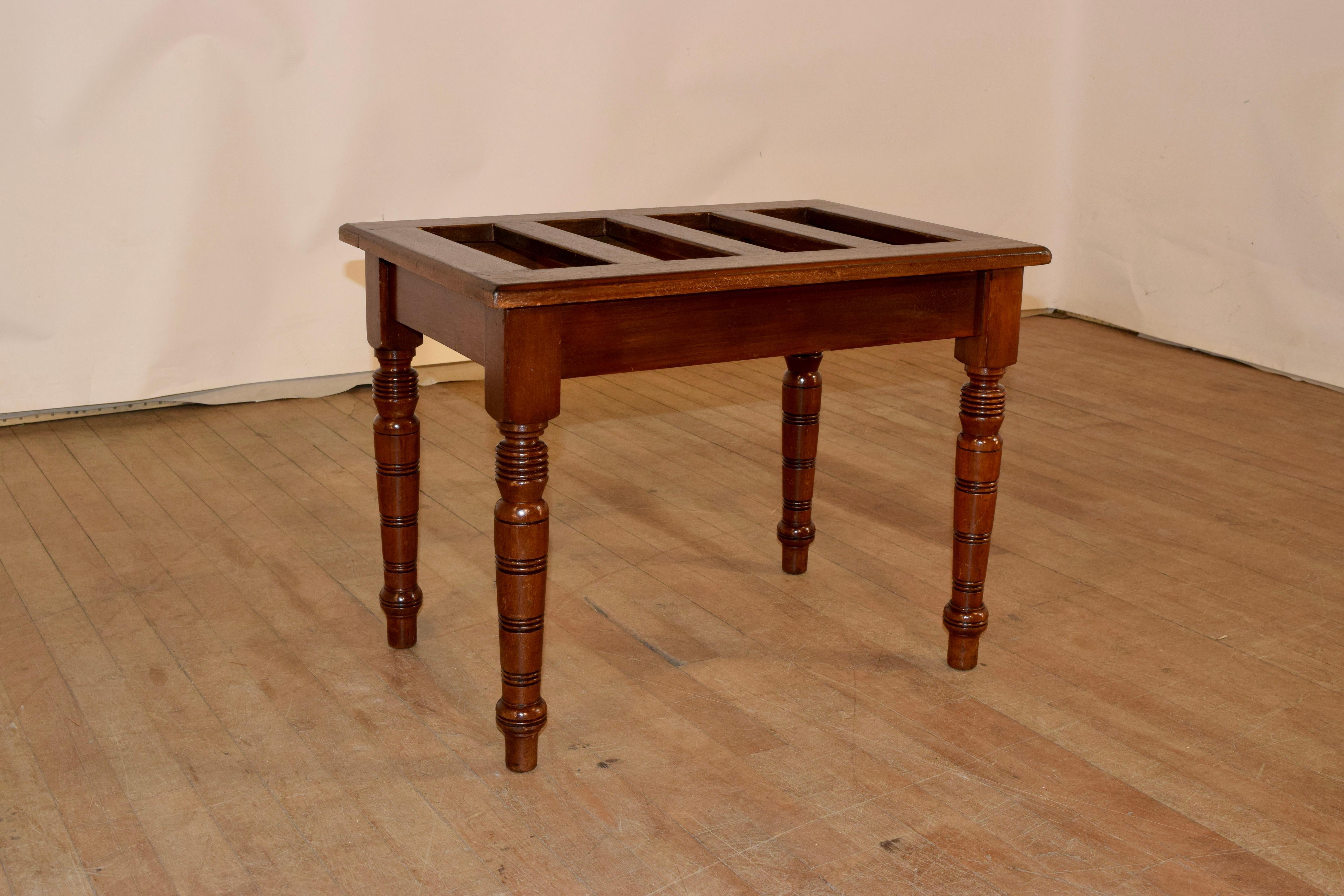 19th Century mahogany luggage stand from England with a slatted top, which has a beveled edge, following down to a simple apron and four hand turned legs. Lovely color and very useful!