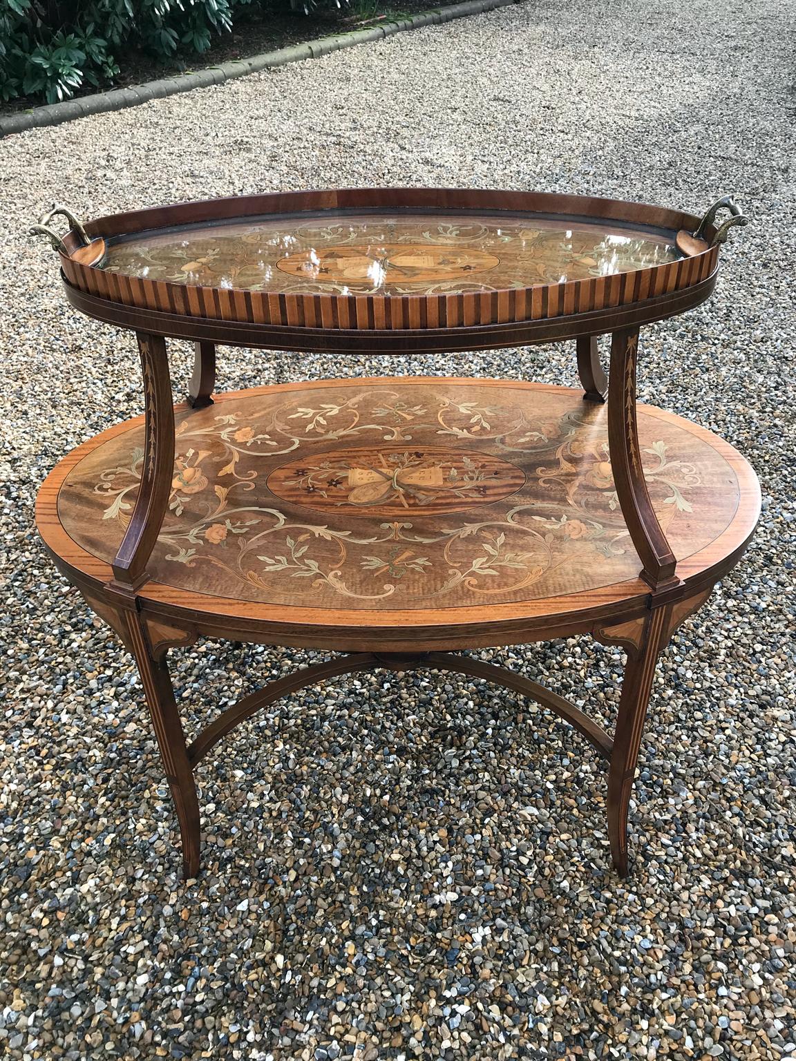 A very high quality English 19th Century Mahogany and Satinwood Marquetry Oval Two Tier Tray Table by London cabinet makers, S & H Jewell, London.

This table consists of two oval tiers, both with a central oval mahogany panel inlaid with musical