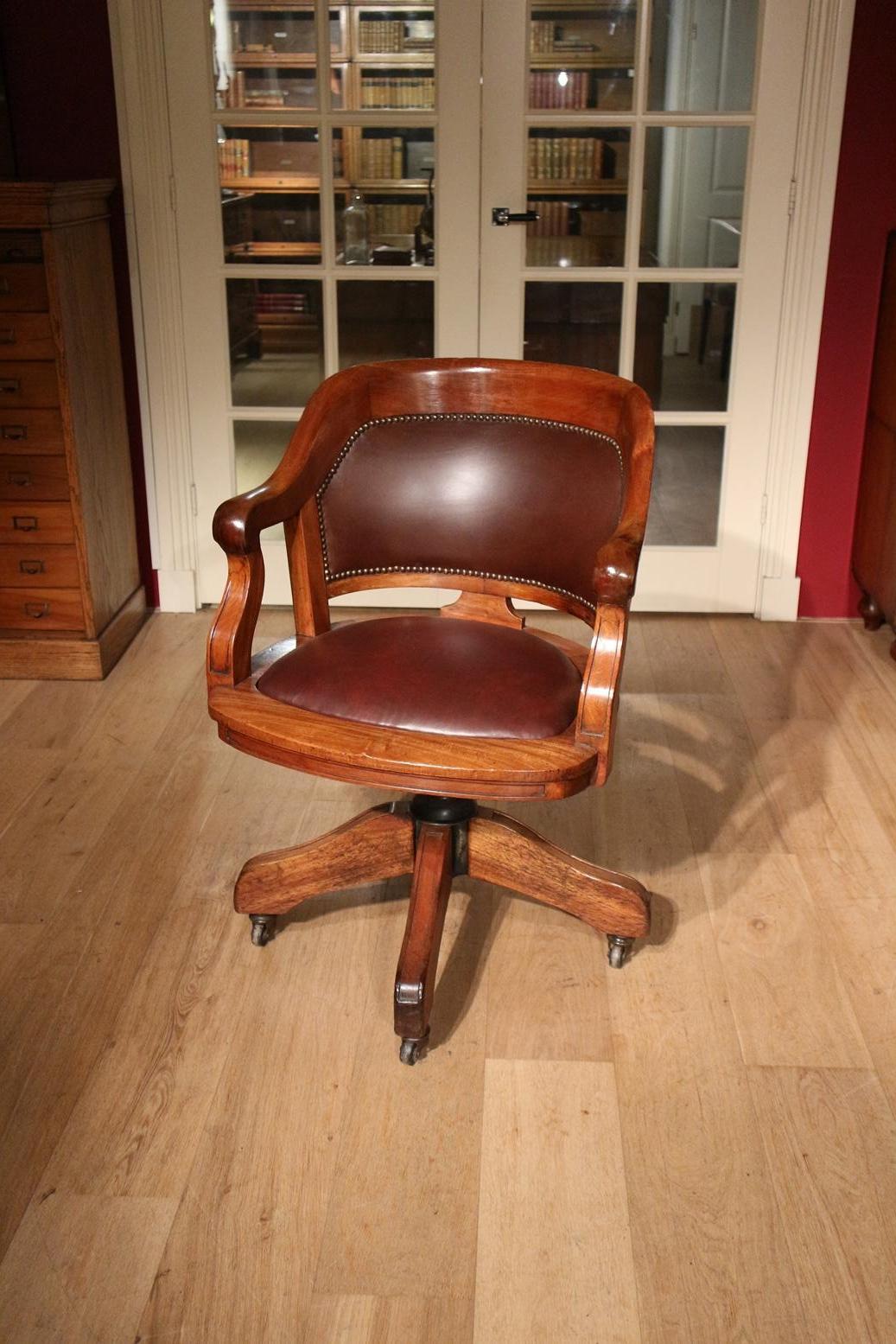 Spacious antique mahogany desk chair with leather upholstery. Chair is height adjustable and equipped with adjustable rocking mechanism. The chair is on iron wheels. Entirely in perfect condition.

Origin: England
Period: Approx. 1900
Size Bro.