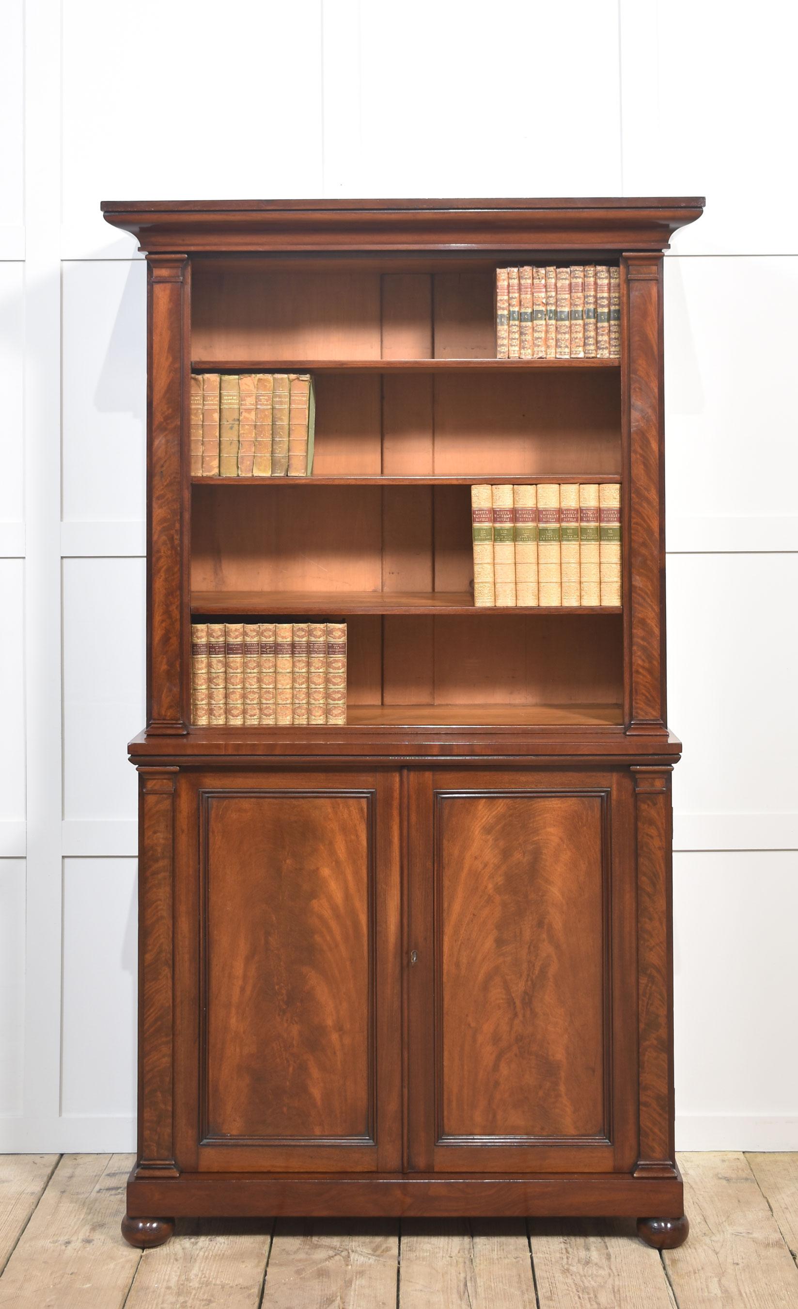 Libreria a giorno in mogano del XIX secolo, il piano rettangolare con cornice modanata sovrasta l'interno a ripiani regolabili fiancheggiato da colonne in mogano. La base è dotata di una coppia di ante pannellate ben strutturate che si aprono per