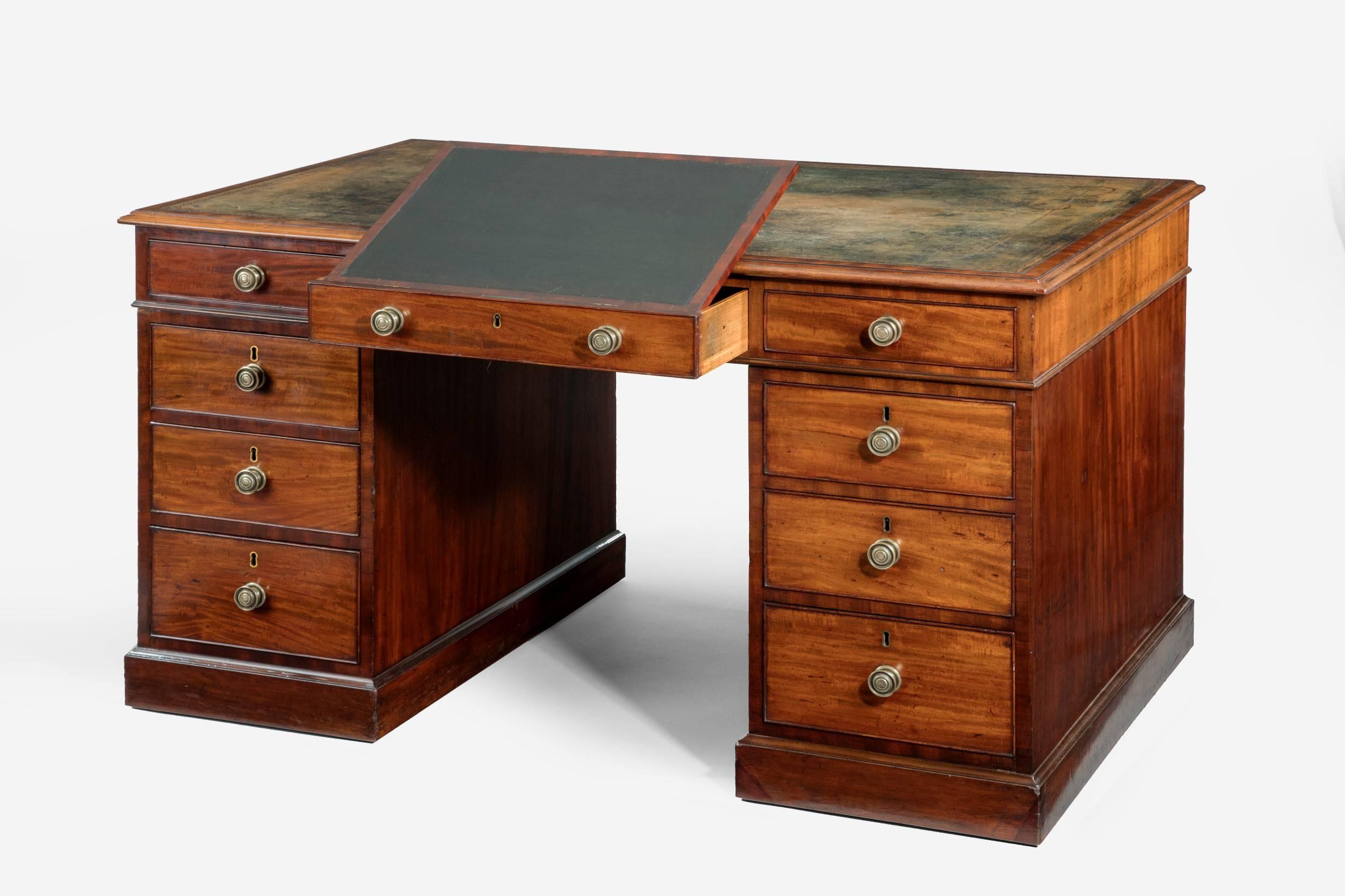 A very fine example of a free standing pedestal partners desk with original inset leather top. A writing slope, also with inset leather, is incorporated in one central drawer.
The whole is in three sections and raised on a plinth base which conceal
