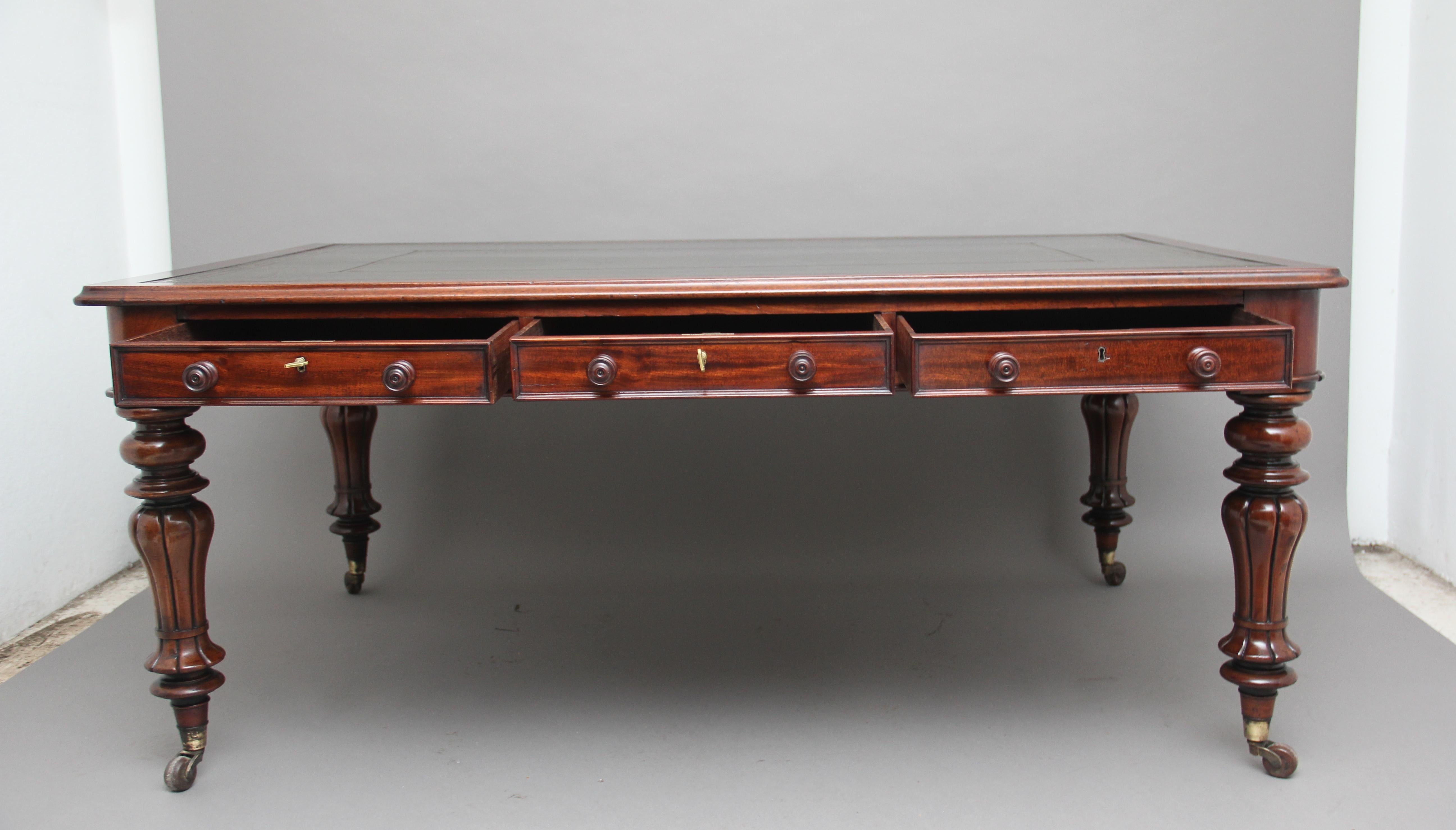 A large mid-19th century mahogany partners writing desk / table, the moulded edge top having a green leather writing surface decorated with gold and blind tooling, having six mahogany lined frieze drawers with mahogany wooden knob handles, standing