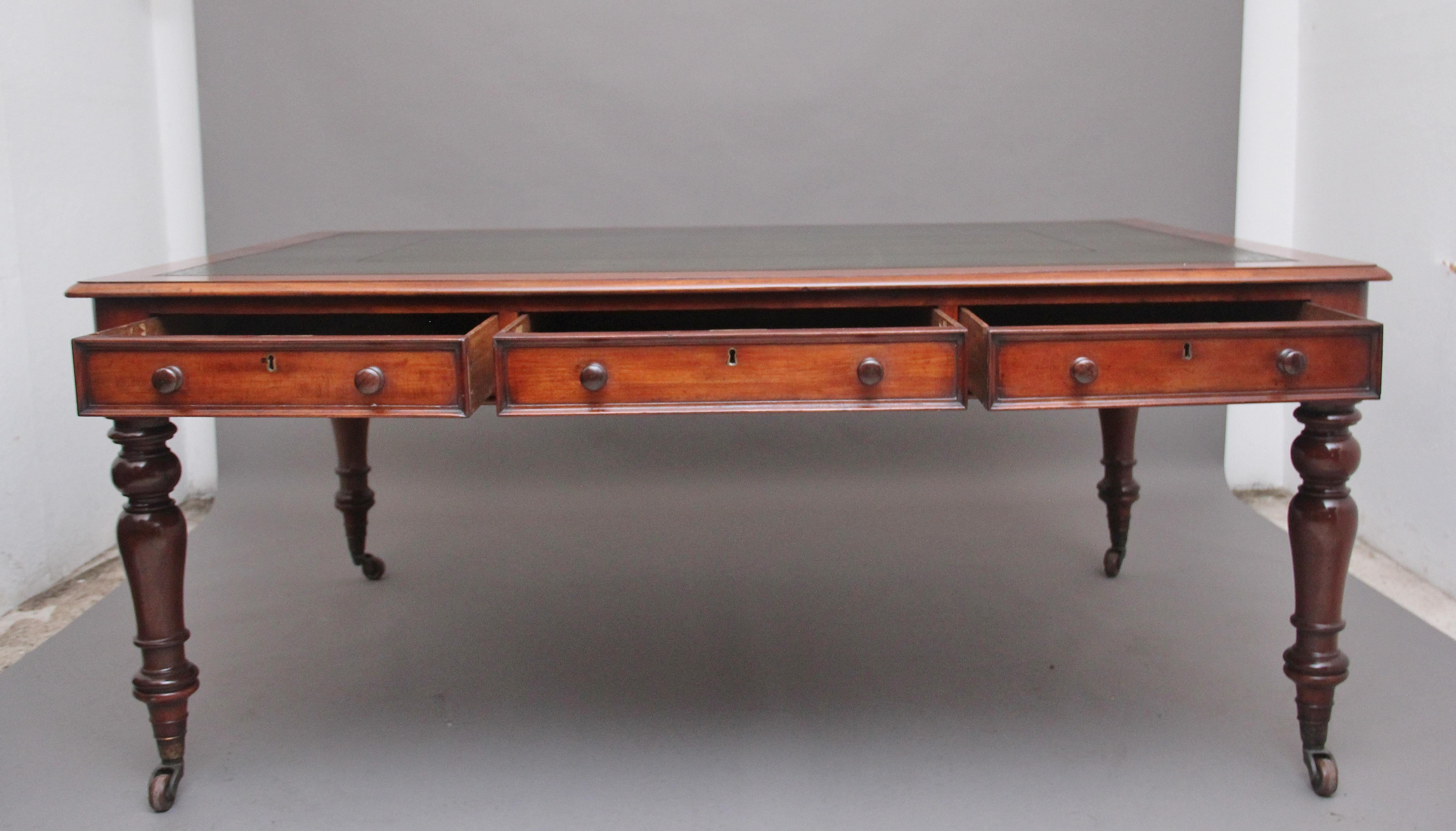 A large mid 19th century mahogany partners writing desk / table, the moulded edge top having a green leather writing surface decorated with gold and blind tooling, having six oak lined frieze drawers with the original mahogany wooden knob handles,