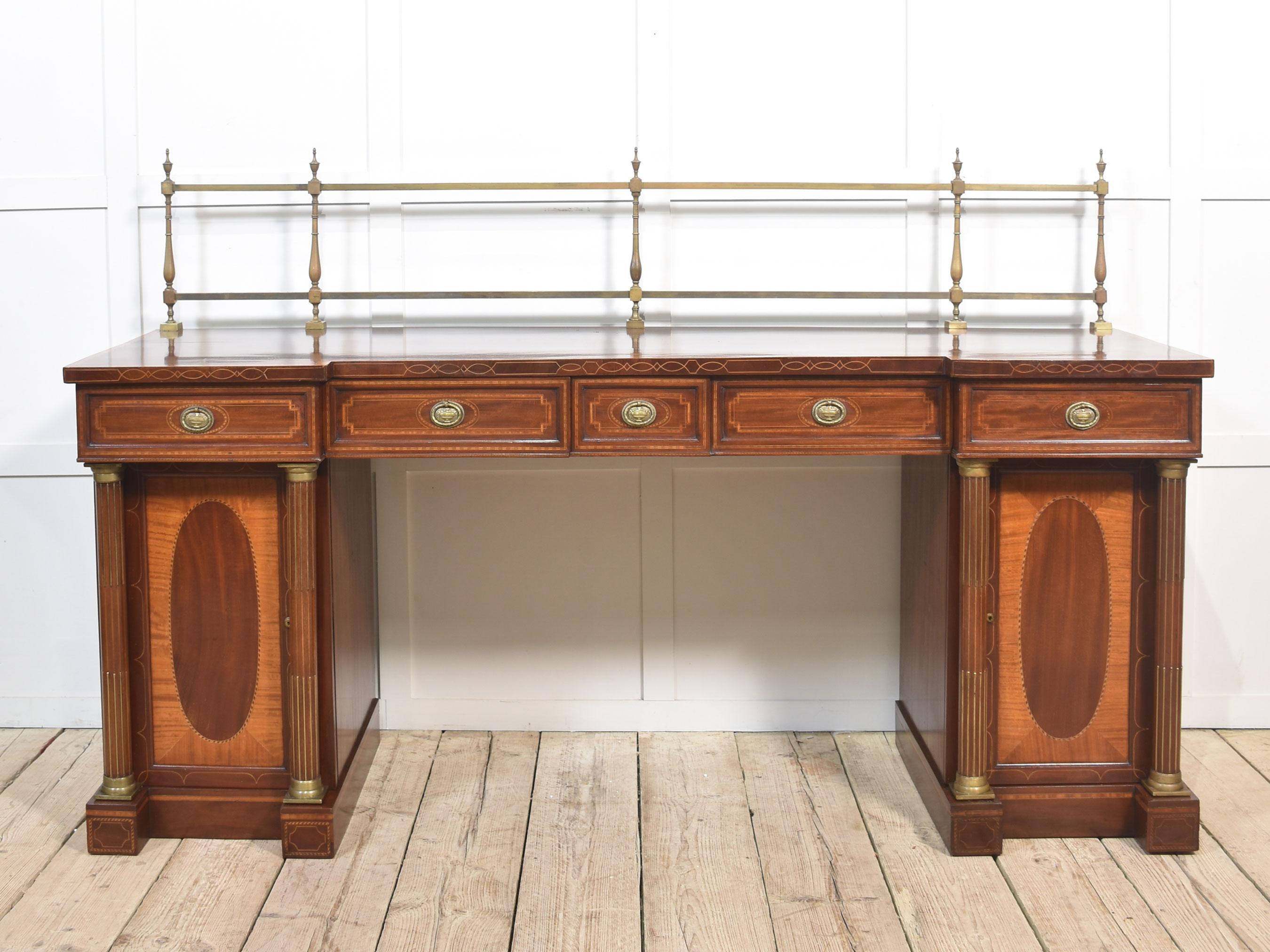 Buffet en acajou marqueté de style Sheraton. Le dossier à galerie surélevée en laiton surplombe un grand plateau inversé en acajou avec un bord en bandeau de satin sur la frise, équipé d'un arrangement de tiroirs, tous dotés de poignées en laiton.