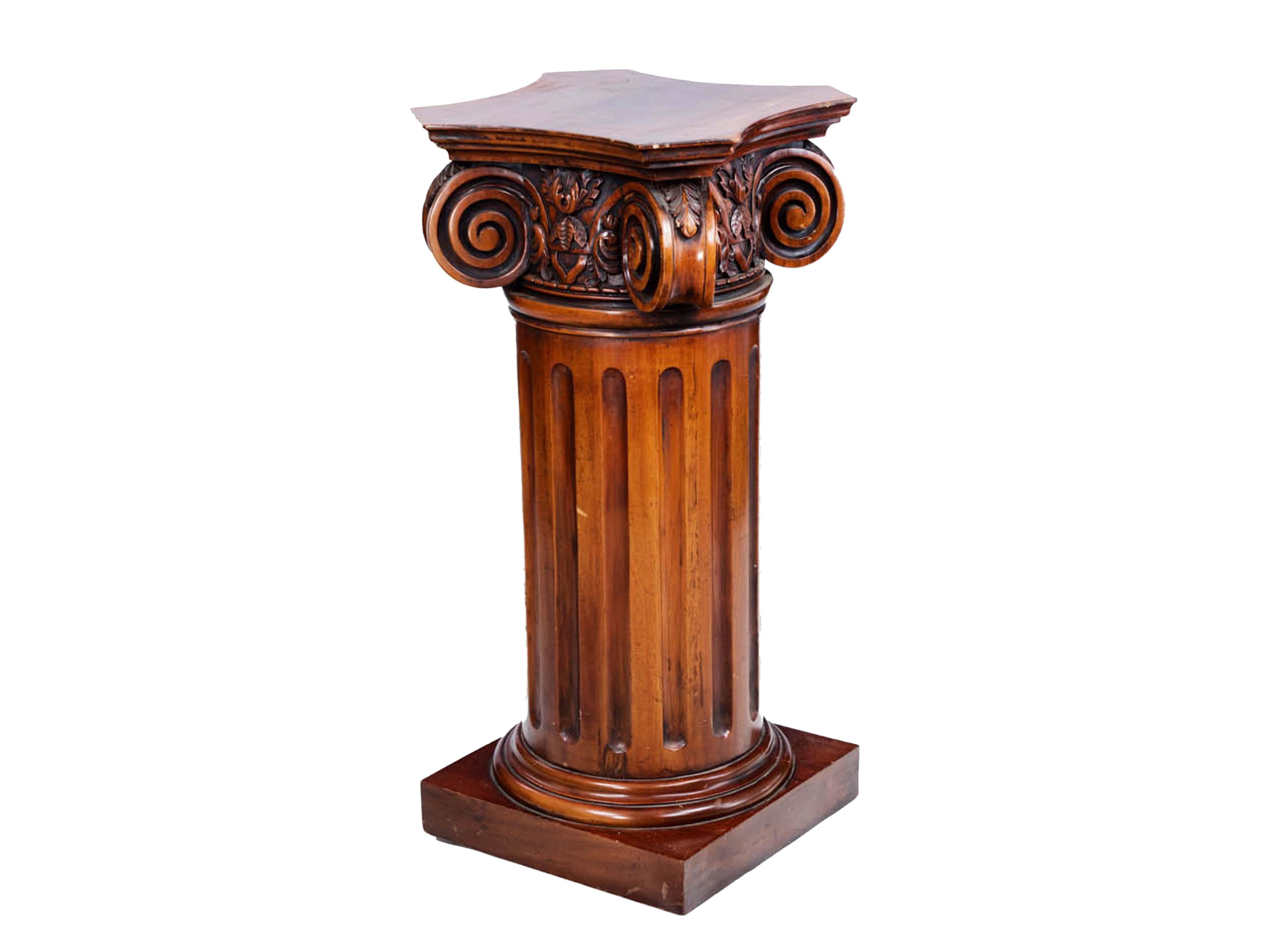 Early 20th century mahogany plinth in the form of a classical-style fluted column with carved Ionic scrolling and Corinthian foliate detail to the capital.