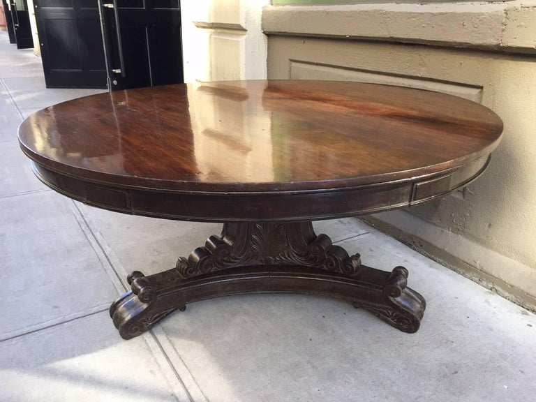 19th century mahogany Regency style center table. This table can be used as a center, breakfast or dining table. Has a pedestal base with heavily carved scroll feet.
   