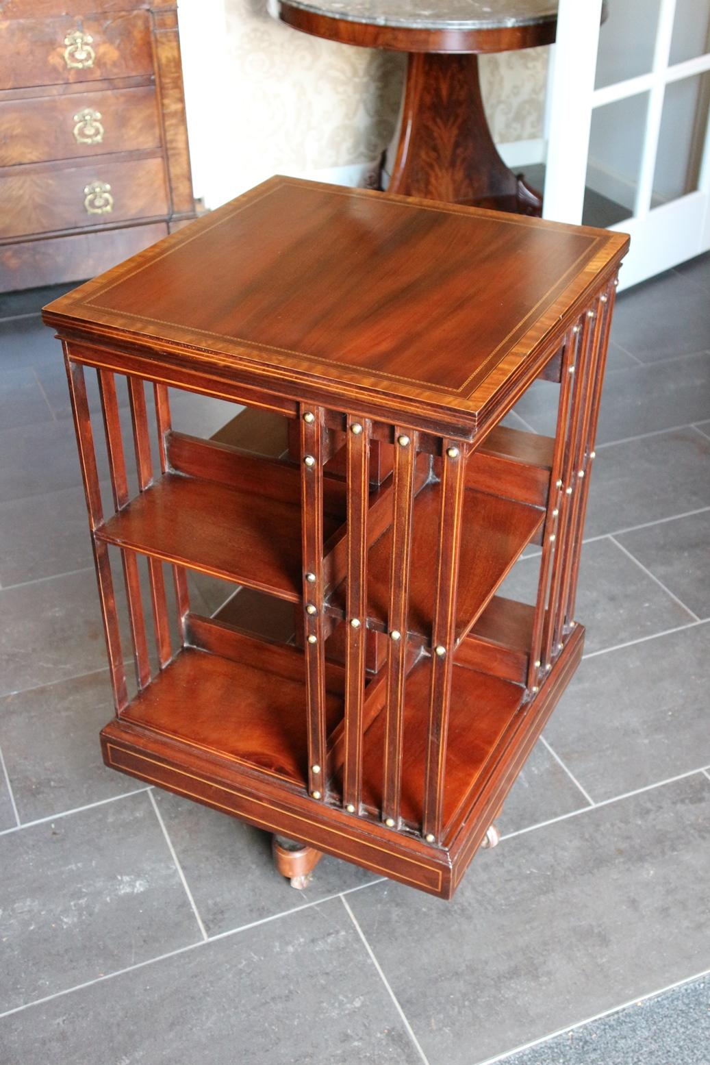 Beautiful antique mahogany revolving bookcase, inlaid with ebony and satin wood. Superb quality revolving bookcase of the famous 19th century English furniture maker Maple & Co. with the typical cast iron base. Nice color and appearance
Origin: