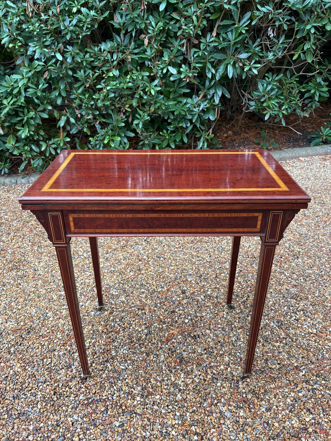 

Table à cartes à abattant en acajou et satiné de très haute qualité du 19e siècle, avec un dos de violon en acajou. Le plateau pivote de 90′ degrés pour s'ouvrir sur une table à cartes avec un intérieur en baize verte. Supporté par des pieds