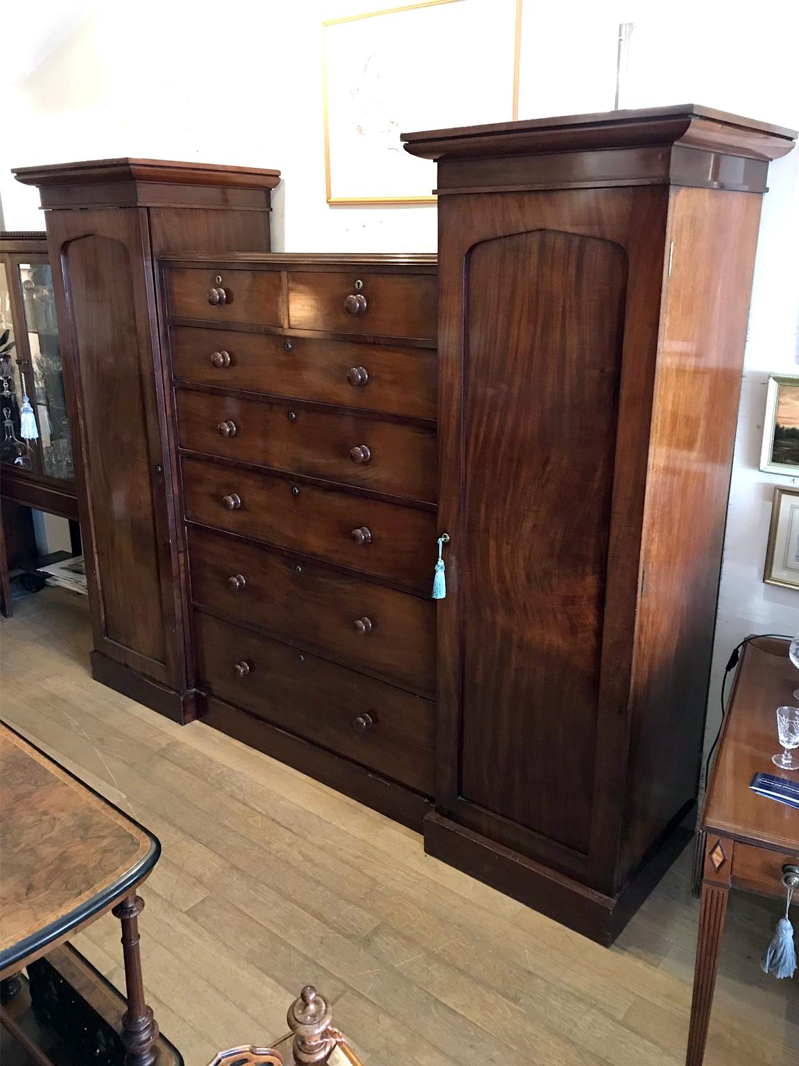 19th century mahogany Sentry wardrobe with two short and five long drawers with bun handles. Two side full length cupboards with hanging space on a plinth base. Comes apart in four sections,

circa 1850 - 1860.

Dimensions:

Width 87.5 inches