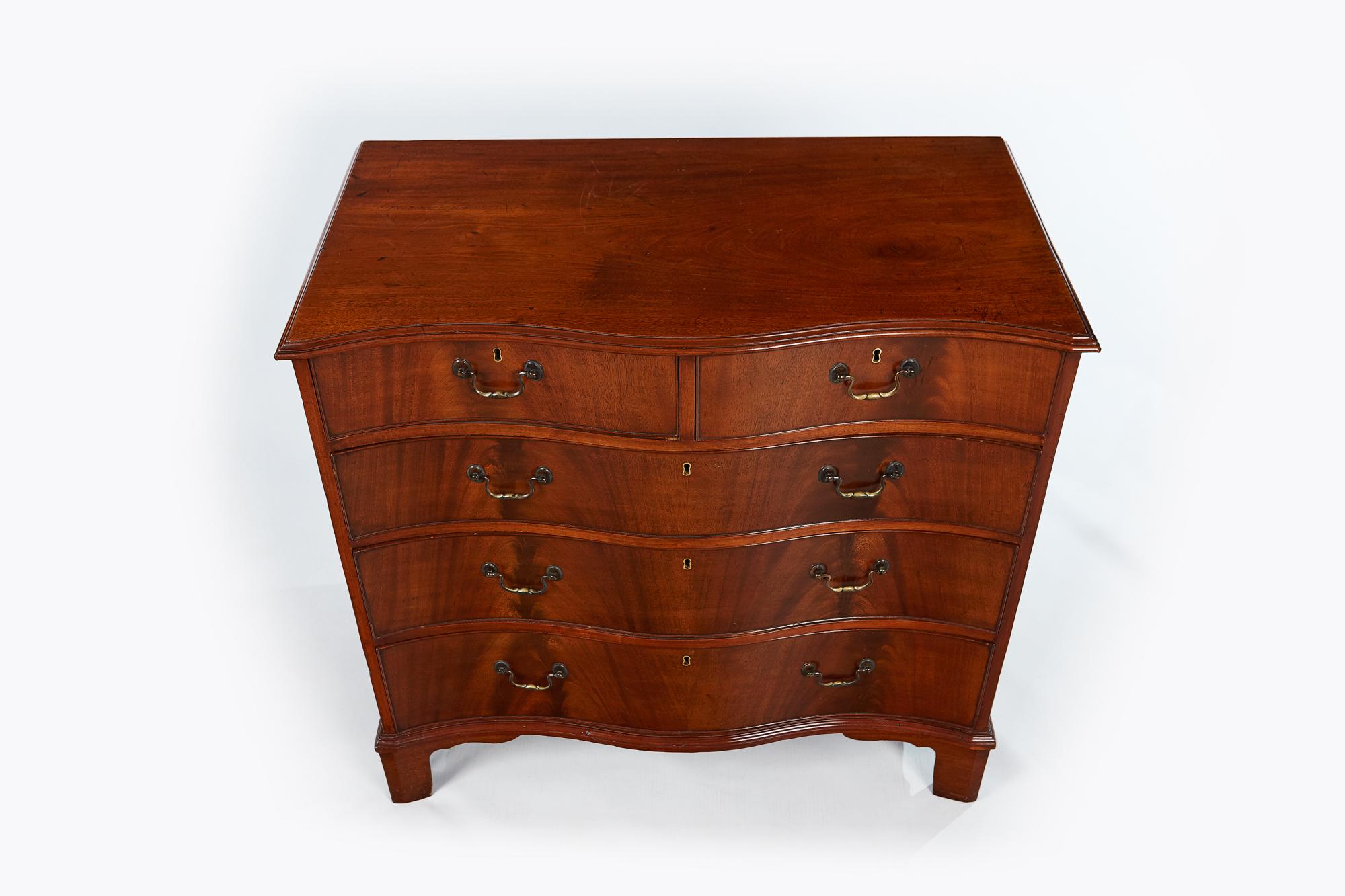 19th century mahogany serpentine chest of drawers with two small and three long graduated drawers with brass pulls supported on four bracket feet.