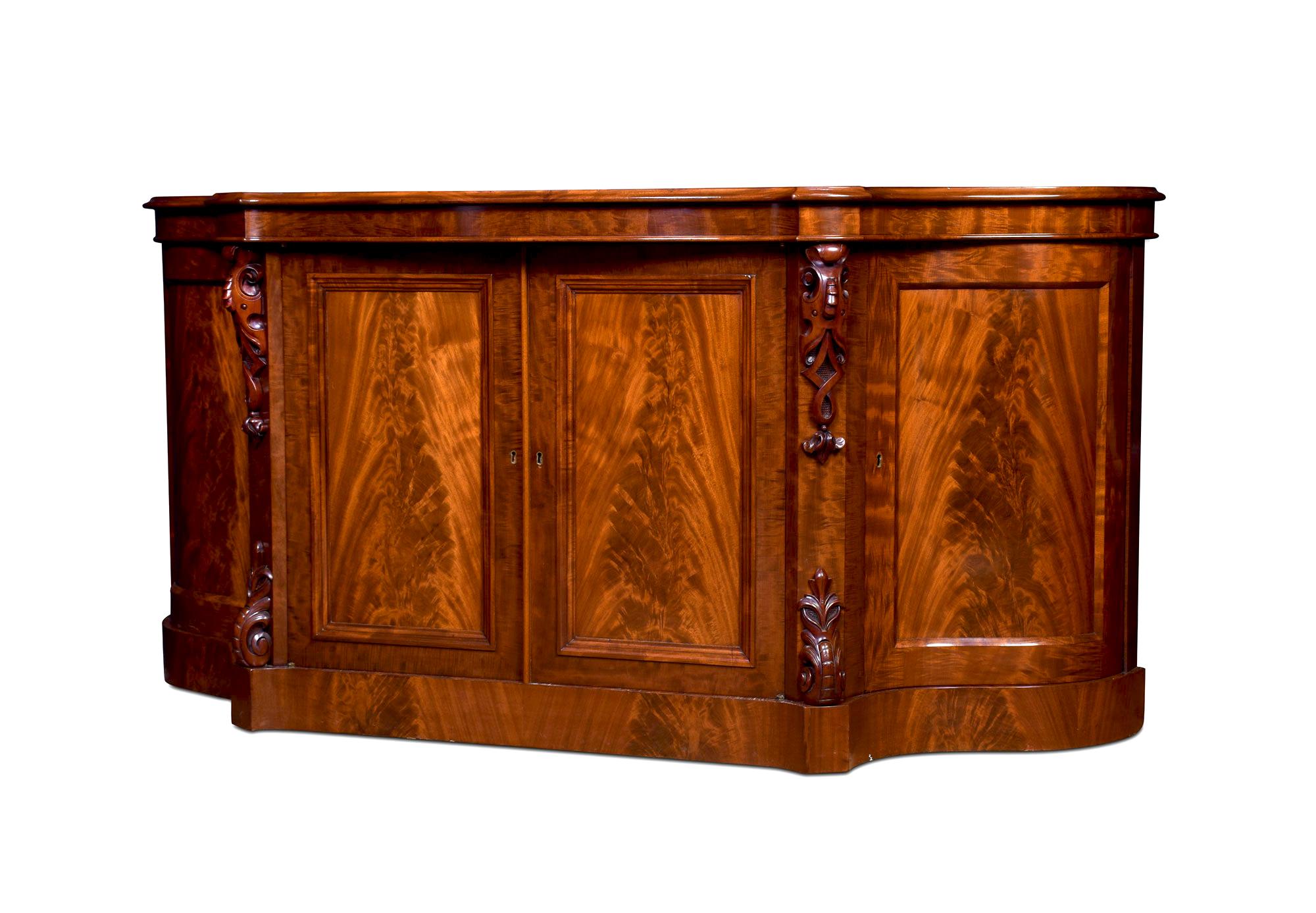Mahogany chiffonier /sideboard, the long shaped moulded top above a plain frieze and a pair of central cupboard doors opening to reveal a shelved interior. Flanked by serpentine cupboard doors. All raised up on a plinth base.
Dimensions:
Height