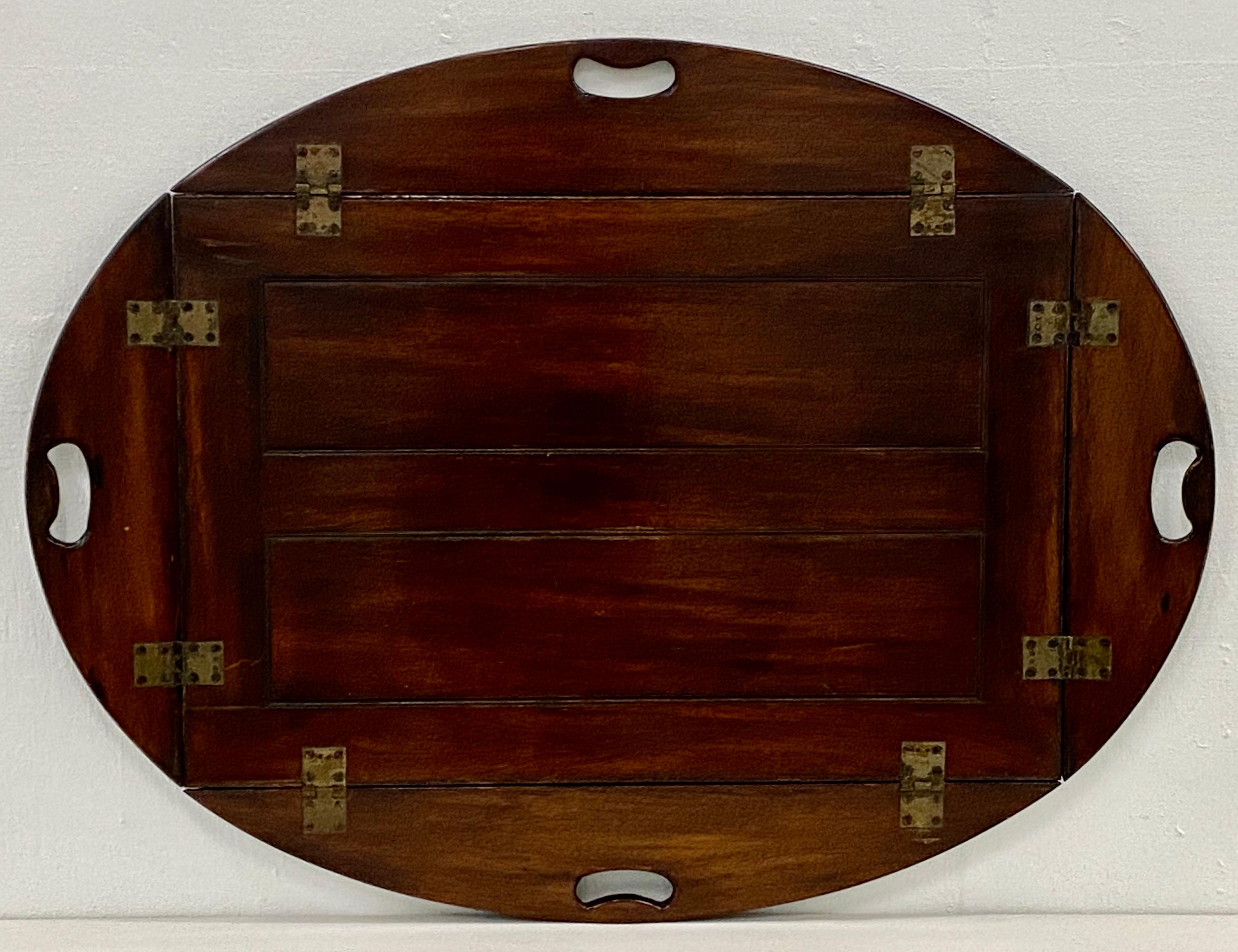 19th century mahogany serving tray

Hand made serving tray from solid mahogany with brass hardware.

The oval tray has four handles along four drop-down sides.

The tray sits atop a folding stand.

Dimensions 39.5
