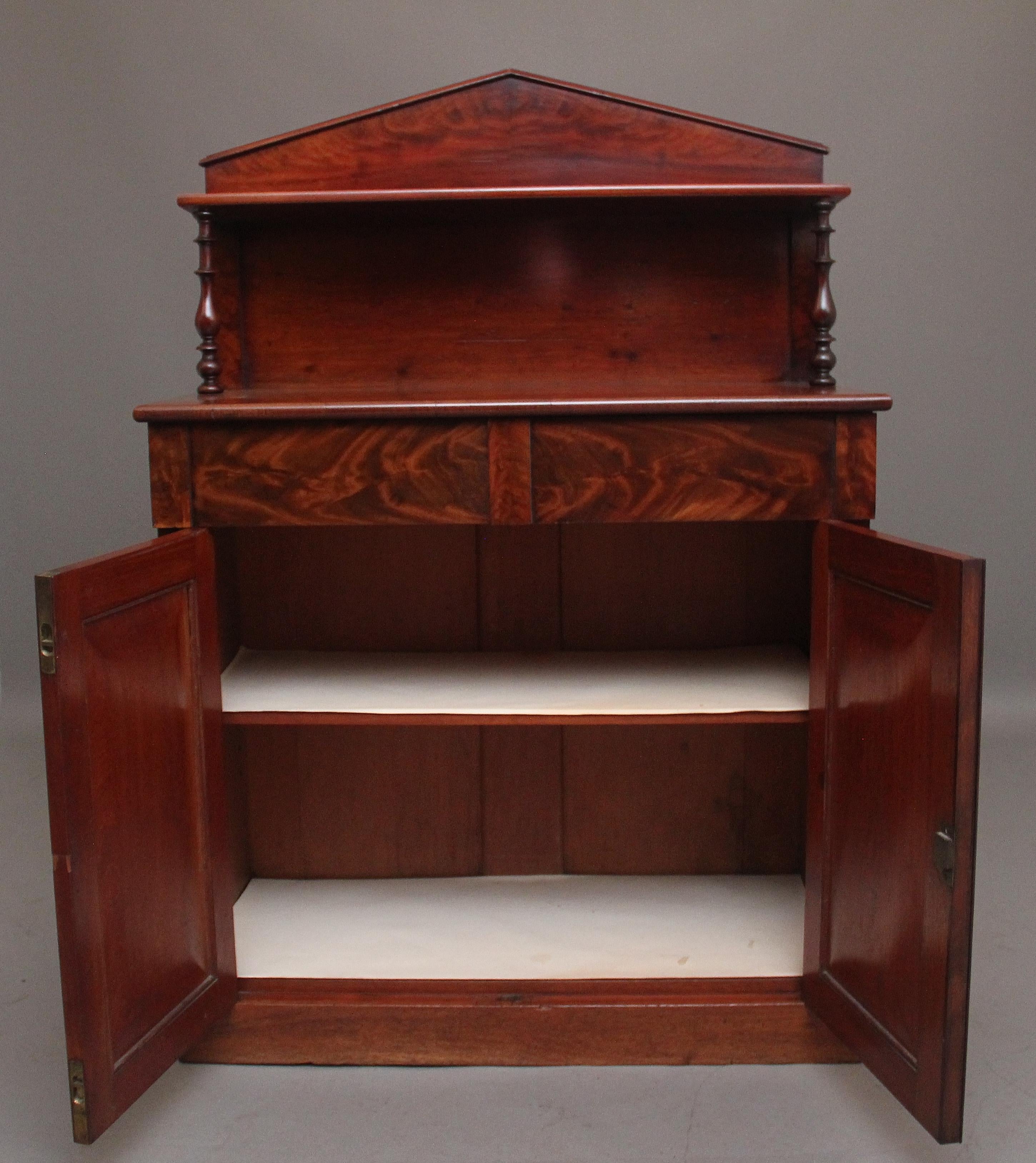 19th Century mahogany chiffonier / side cabinet, the arched cornice with a panelled back, finely turned columns supporting a single shelf, the bottom section having two frieze drawers above two panelled cupboard doors opening to reveal a single