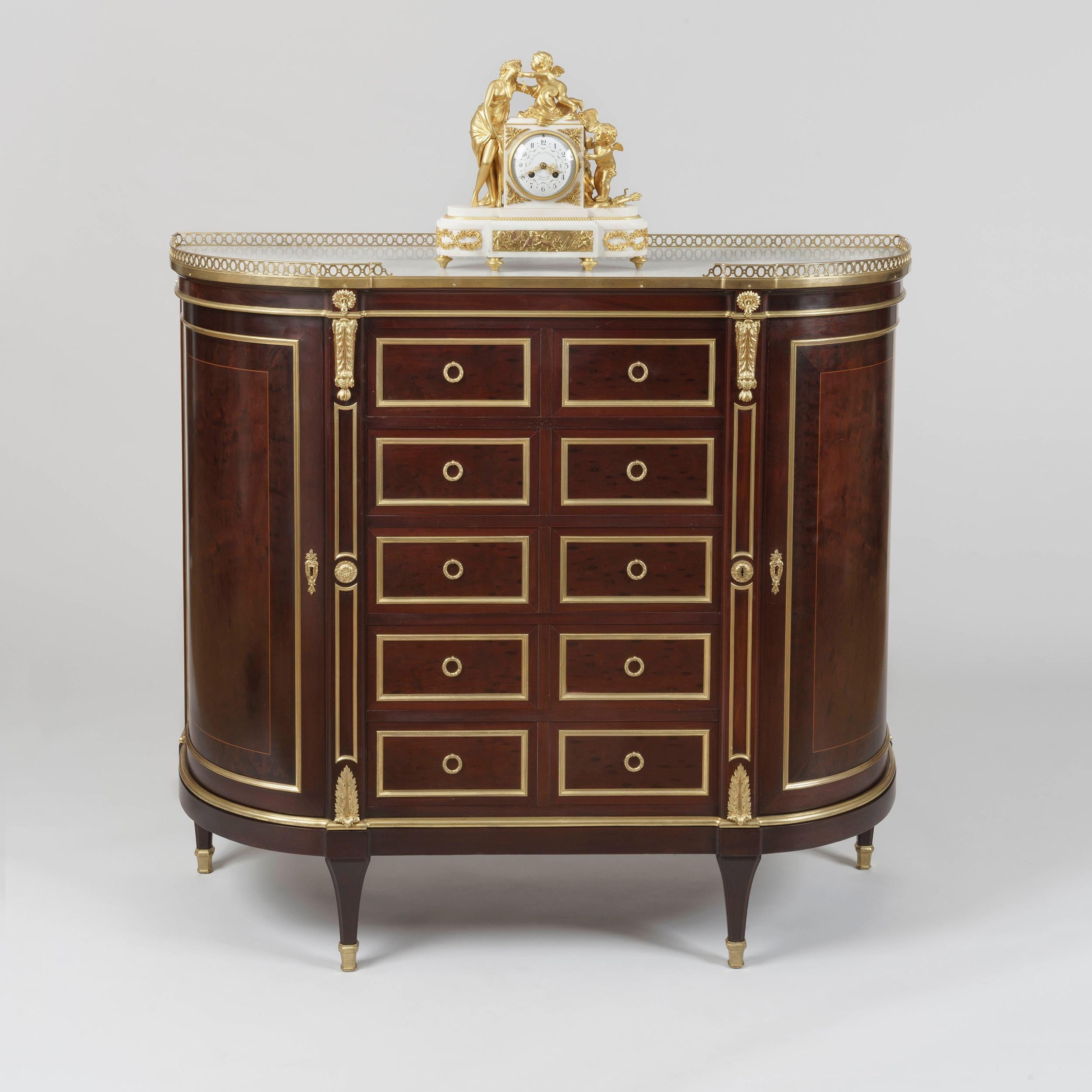 A fine side cabinet in the Louis XVI manner
By G. Durand of Paris

Of elegant demilune form and employing exquisite flamed Cuban mahogany, the whole dressed with restrained neoclassical mounts in the manner of Jean-Henri Riesener; rising from